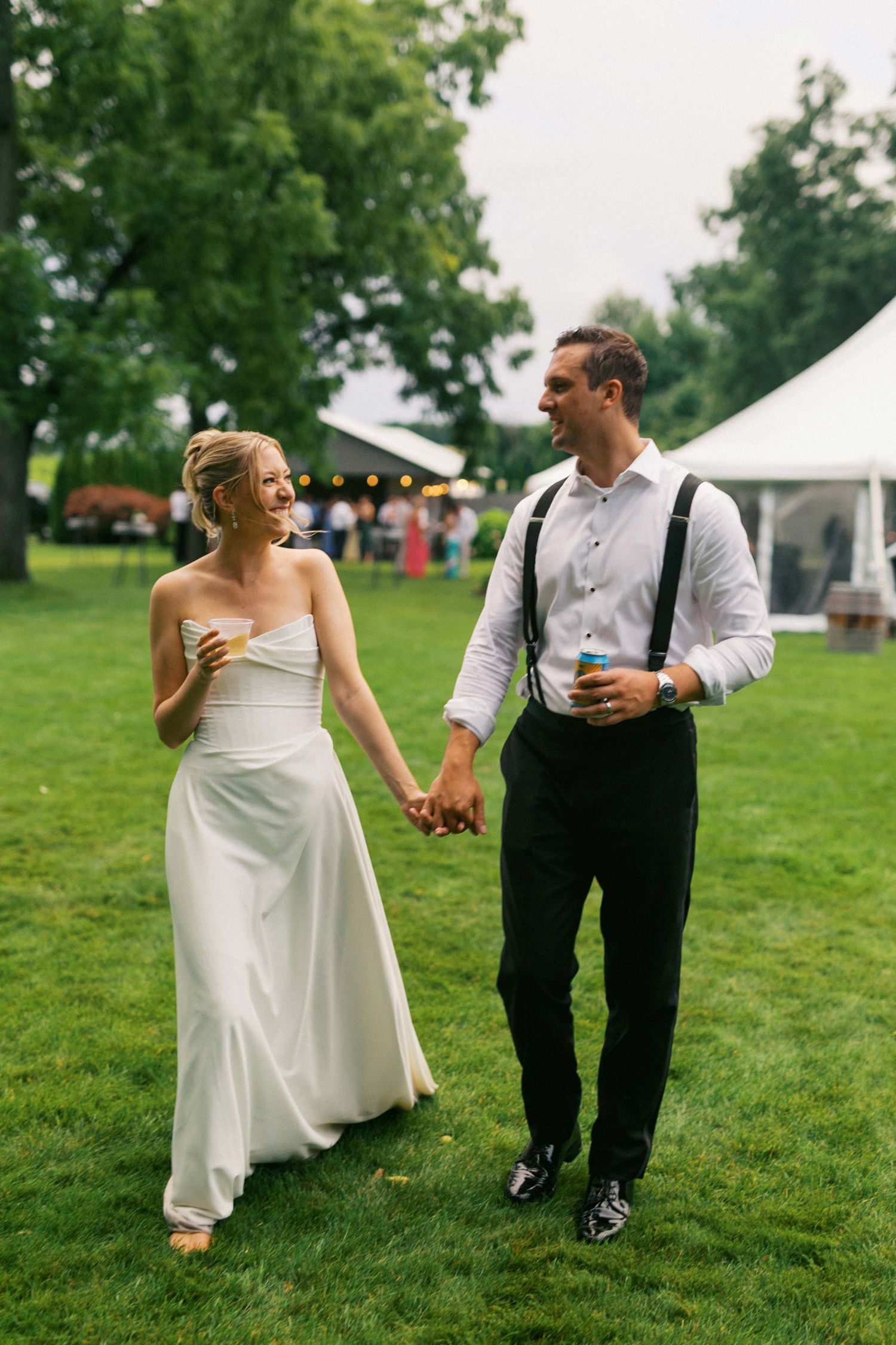 A couple in wedding attire walks together on a grassy lawn in a series of candid shots showing playful interaction.