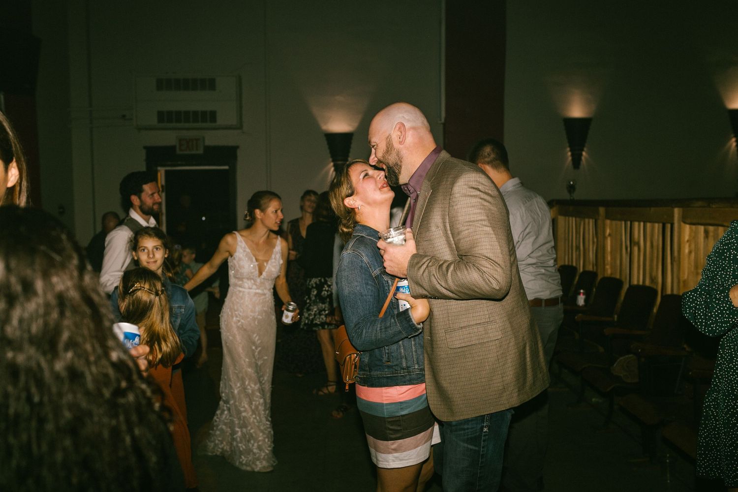 Couples dance together at an evening wedding reception with warm lighting and elegant decor.