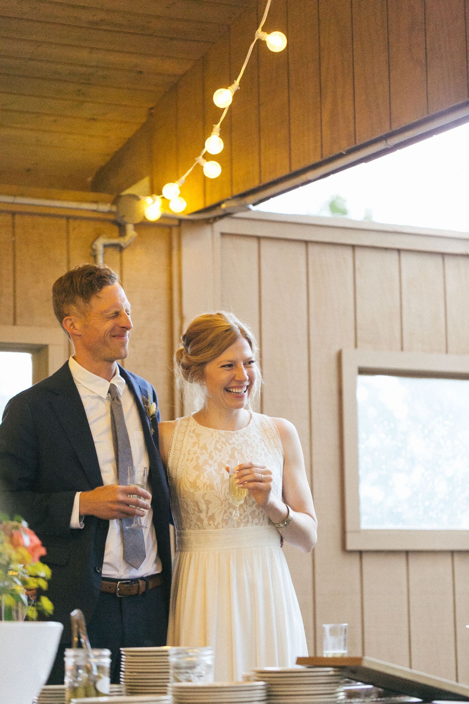 Wedding couple sharing a moment together during their reception under warm string lights.