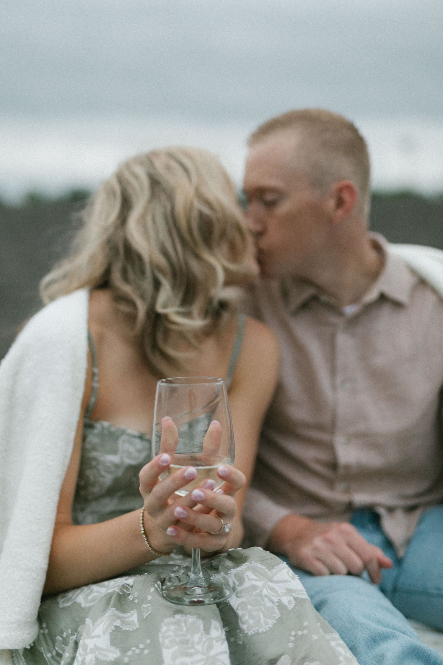 A romantic moment shared over a glass of wine on a cloudy afternoon.