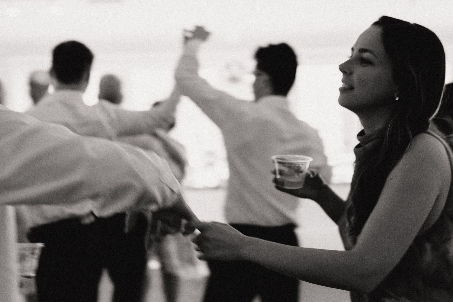 Silhouettes of wedding guests dancing at a lively reception.