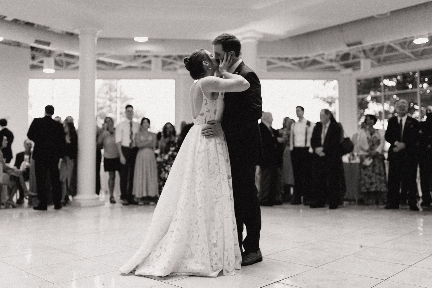 Couple dancing together in formal attire at an elegant indoor reception venue.