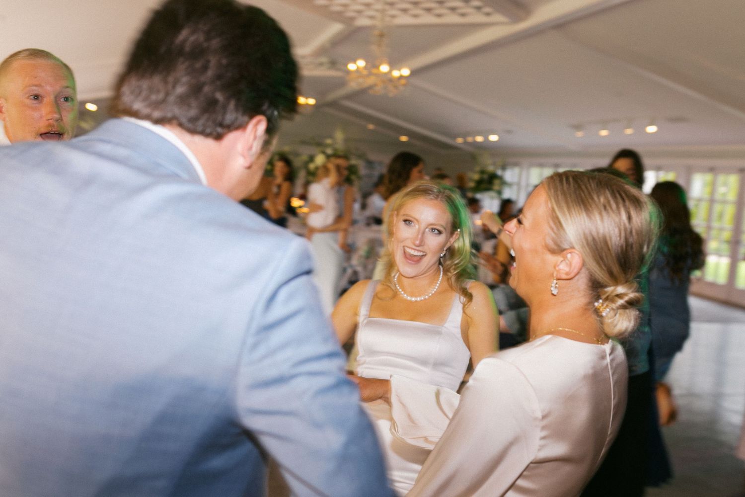 Wedding guests mingling and socializing during an indoor reception celebration.