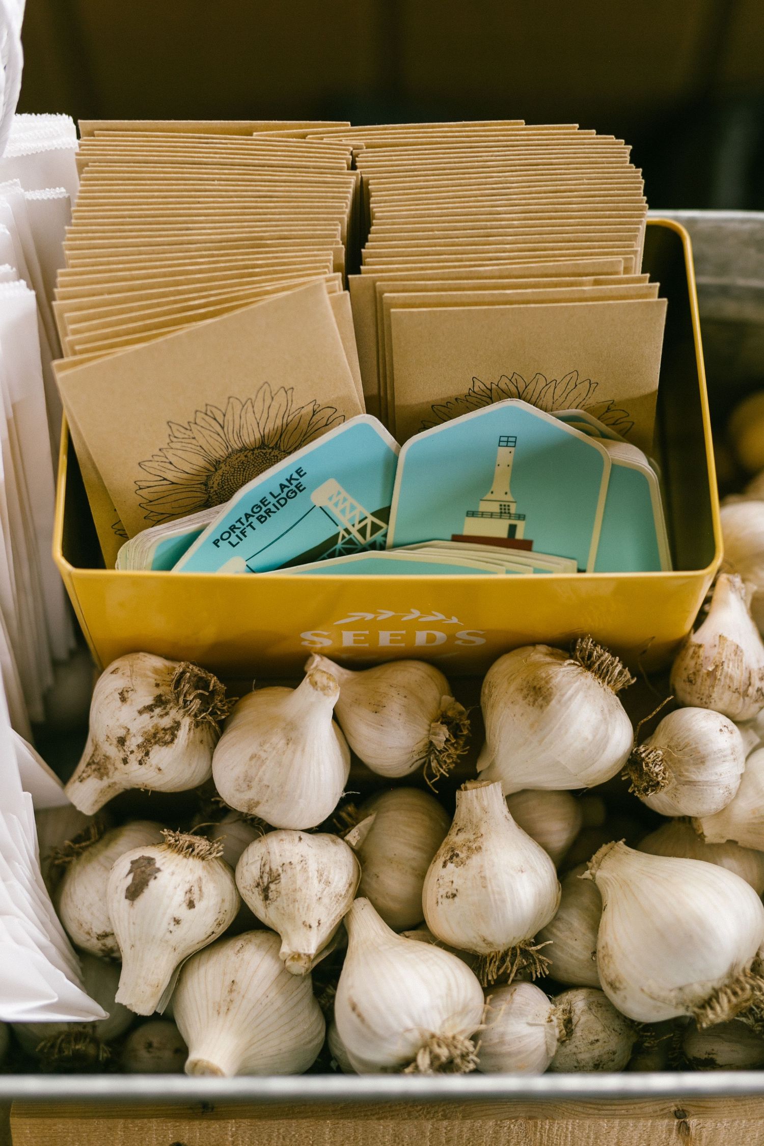 Decorative cards and garlic bulbs arranged in yellow containers.