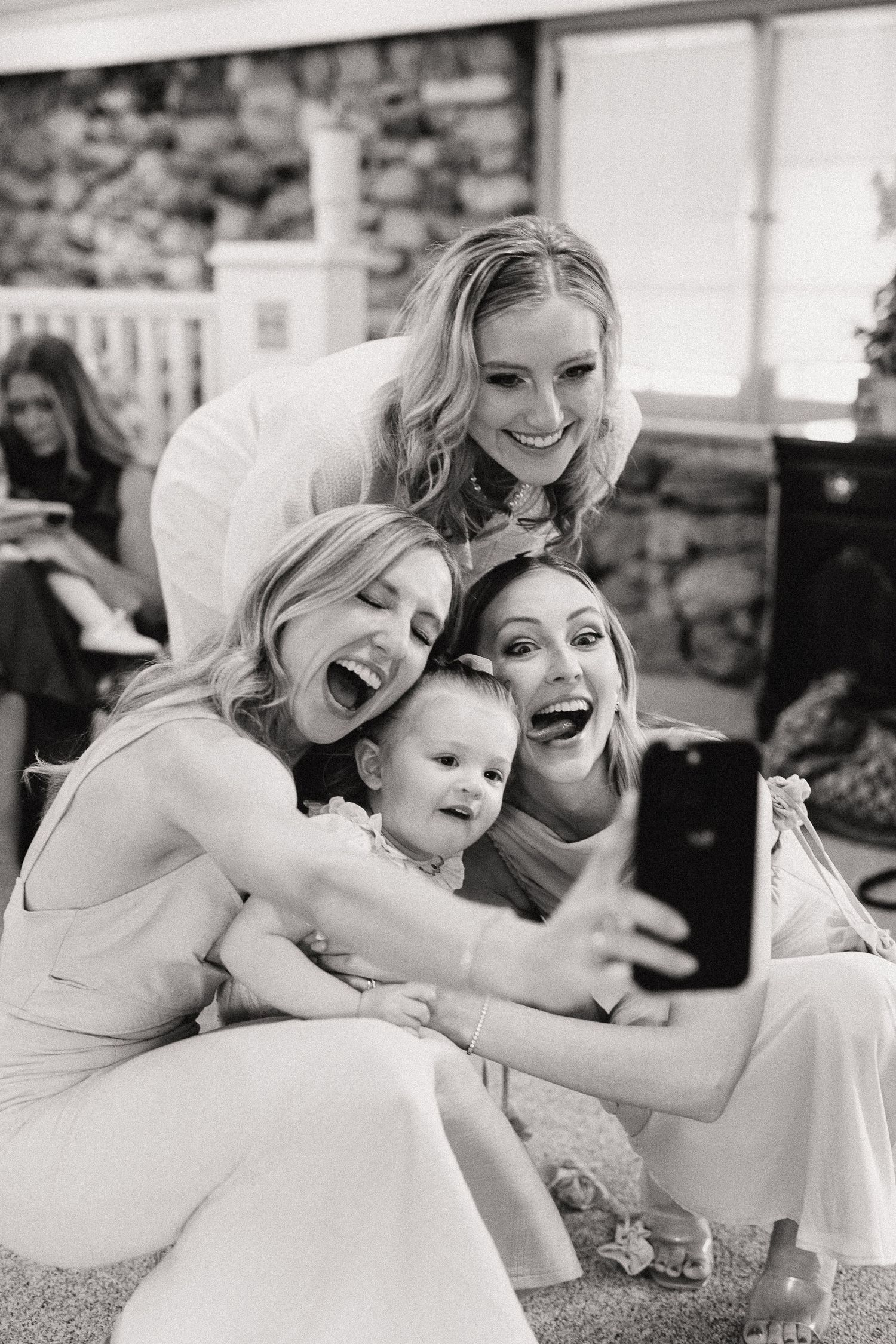 A series of joyful candid moments showing people embracing and laughing together in black and white.
