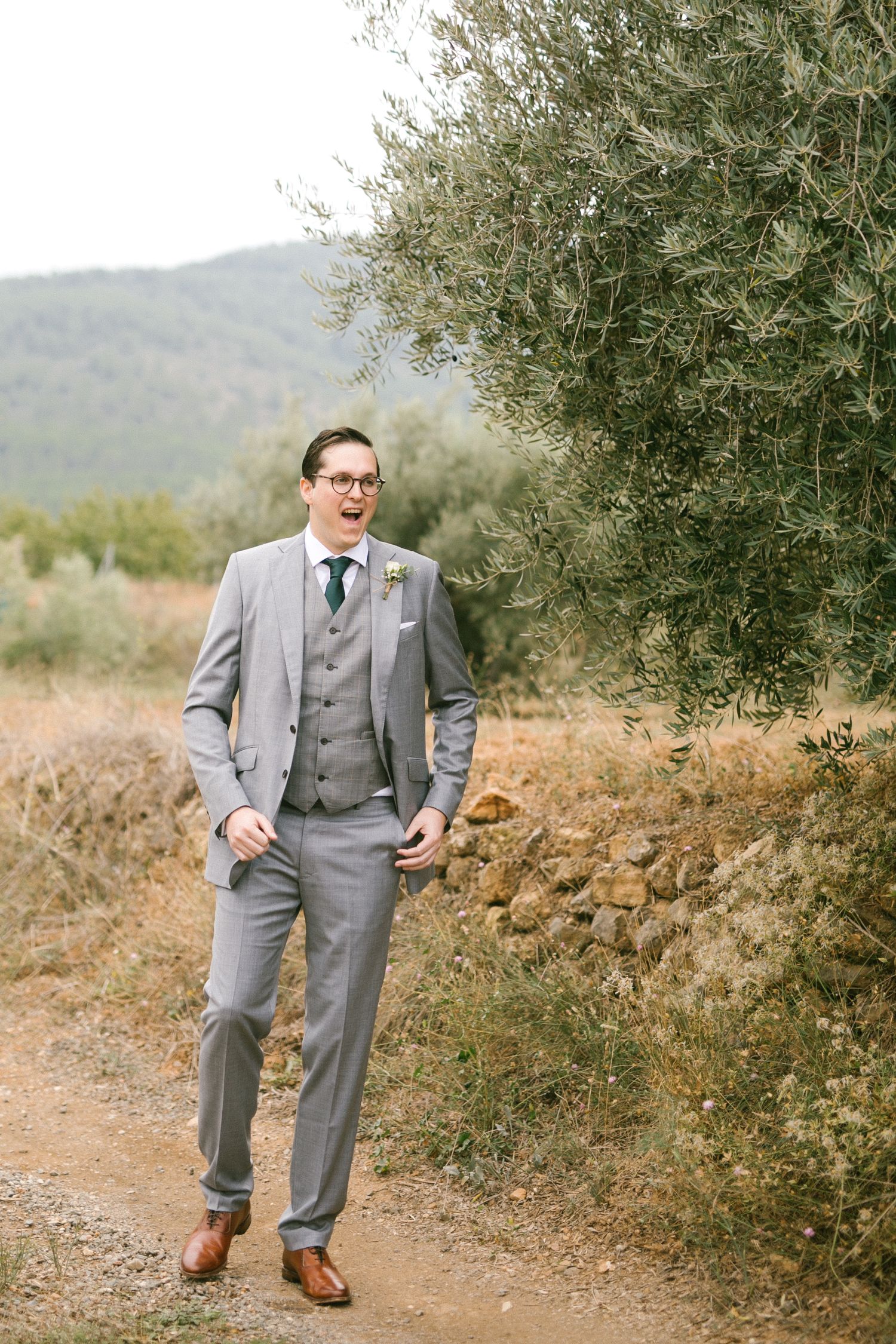 A groom sees his bride for the first time along a rustic path beside olive trees in Murcia Spain.