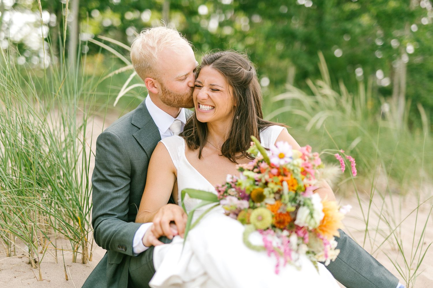 Romantic couple portraits in a sunlit field with summer flowers.