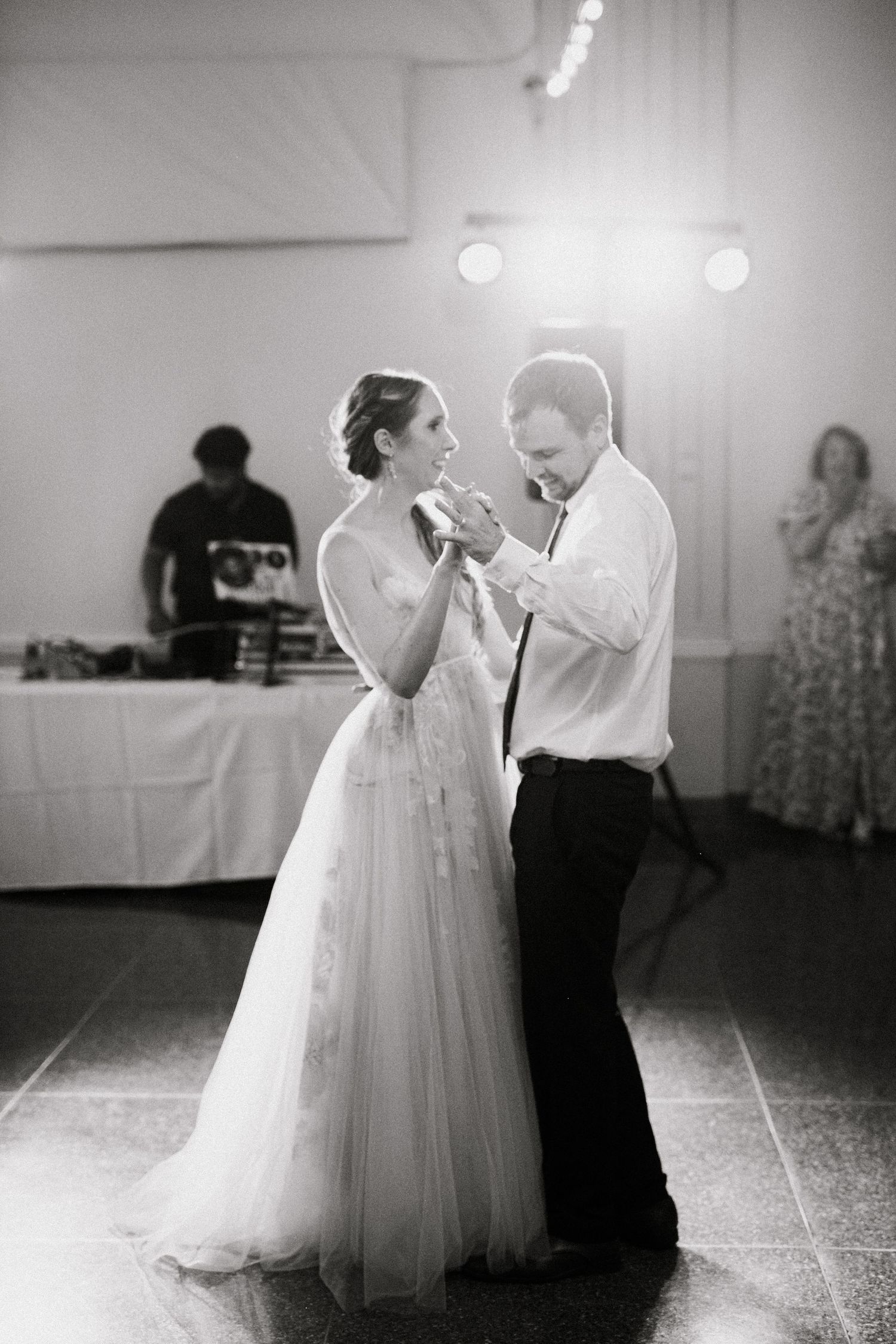 Black and white photo sequence showing a couple dancing together at a wedding reception on a dance floor.