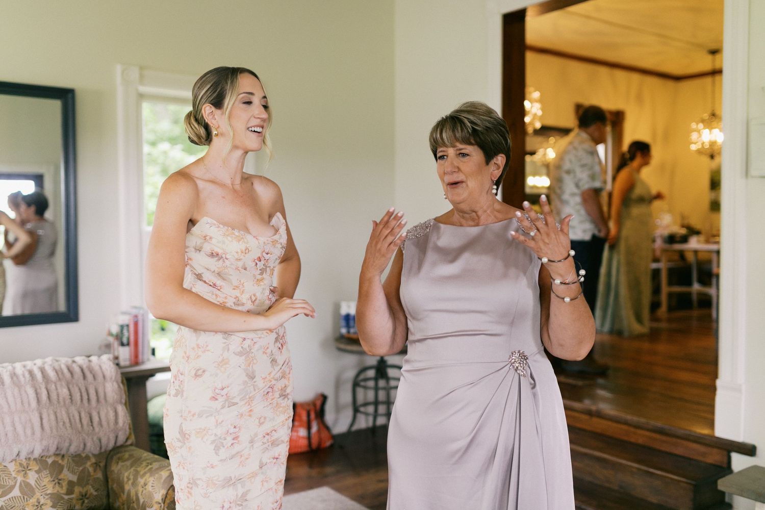 A mother and sister of the bride become emotional upon seeing the bride.