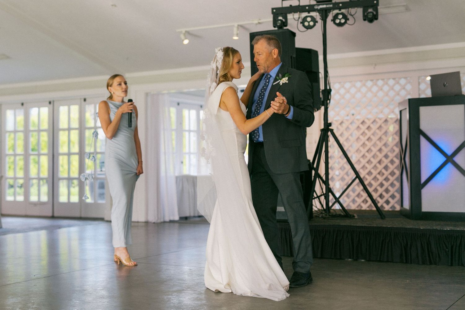 Couples dancing and spinning across a bright reception hall with elegant lighting.