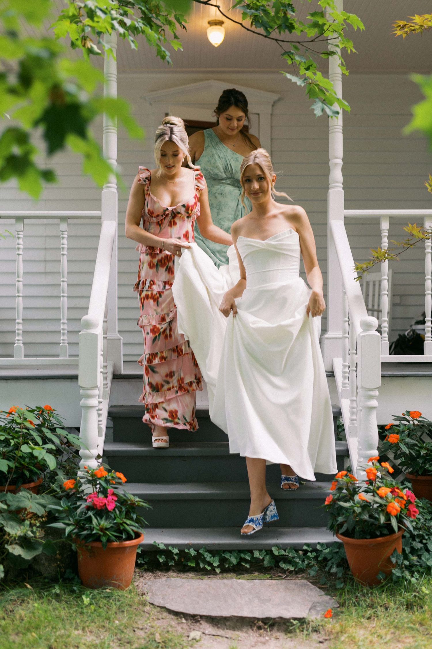 Two bridesmaids help a bride go to her first look.