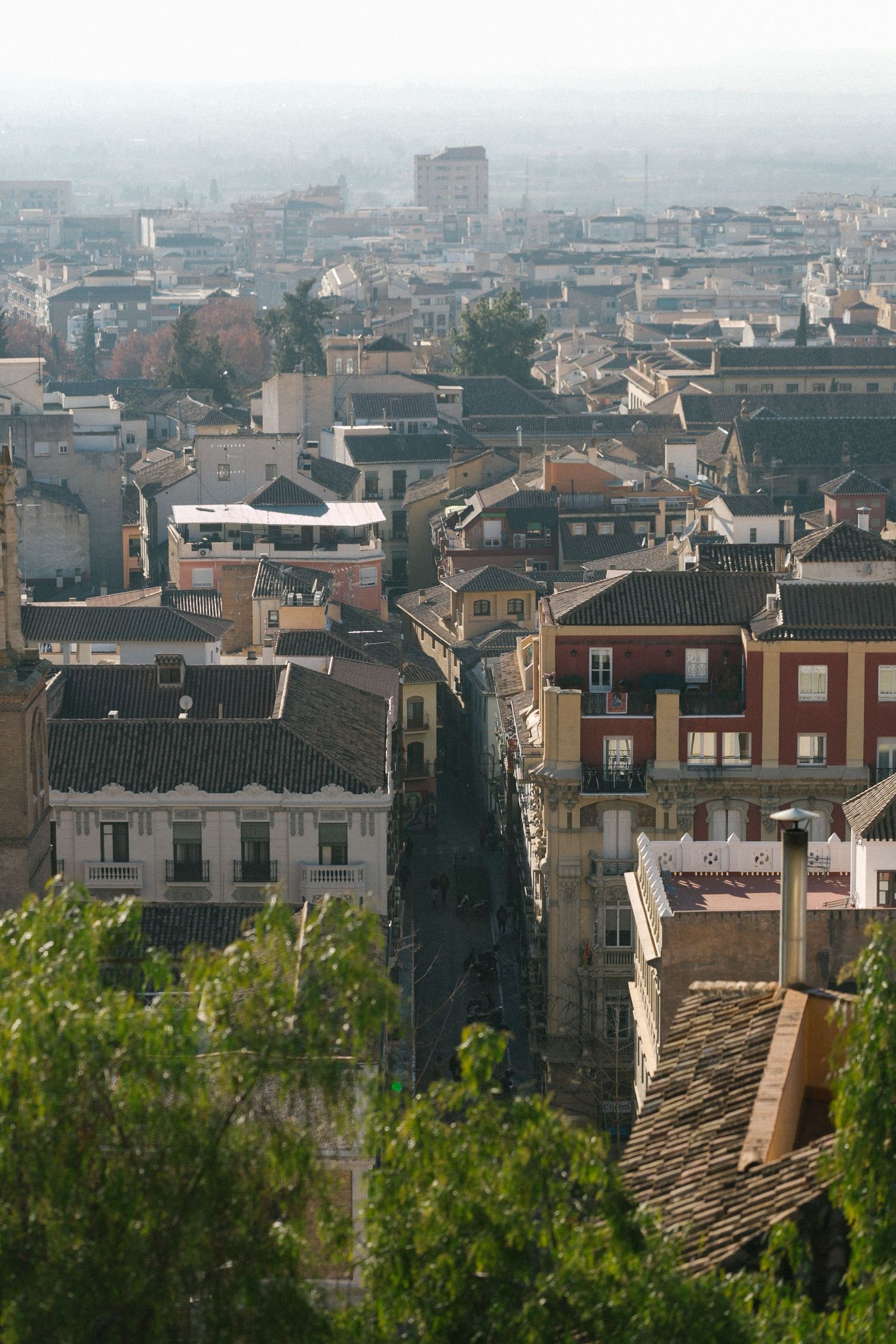 Aerial view of Granada's historic cityscape with tiled roofs and narrow streets.