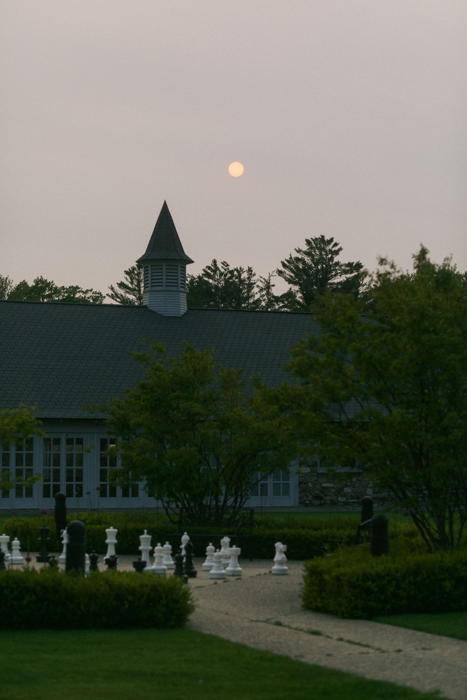 Beautiful sunset view of a church or venue building with spire against a dusky sky.