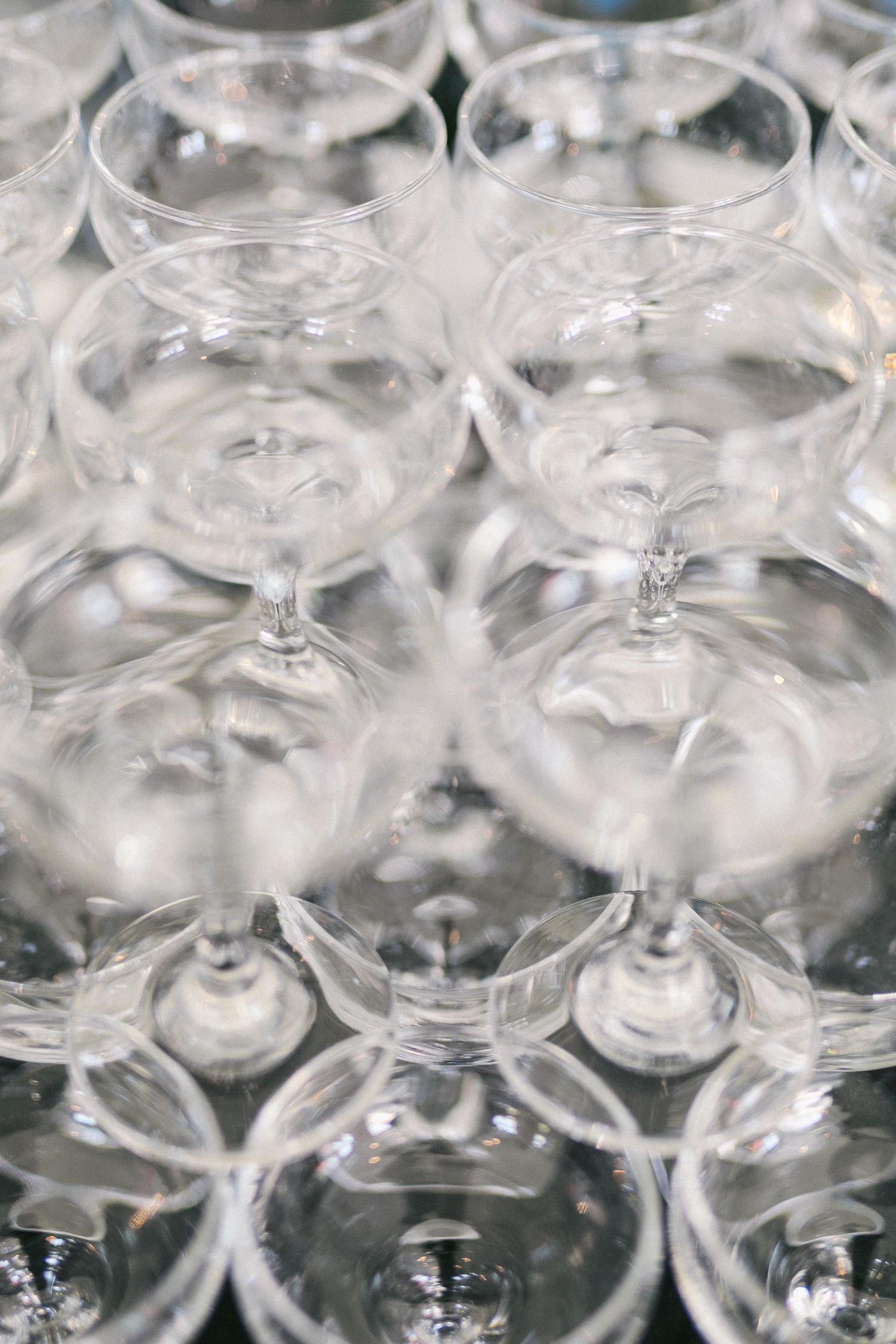 Rows of empty wine glasses arranged for a wedding reception celebration.