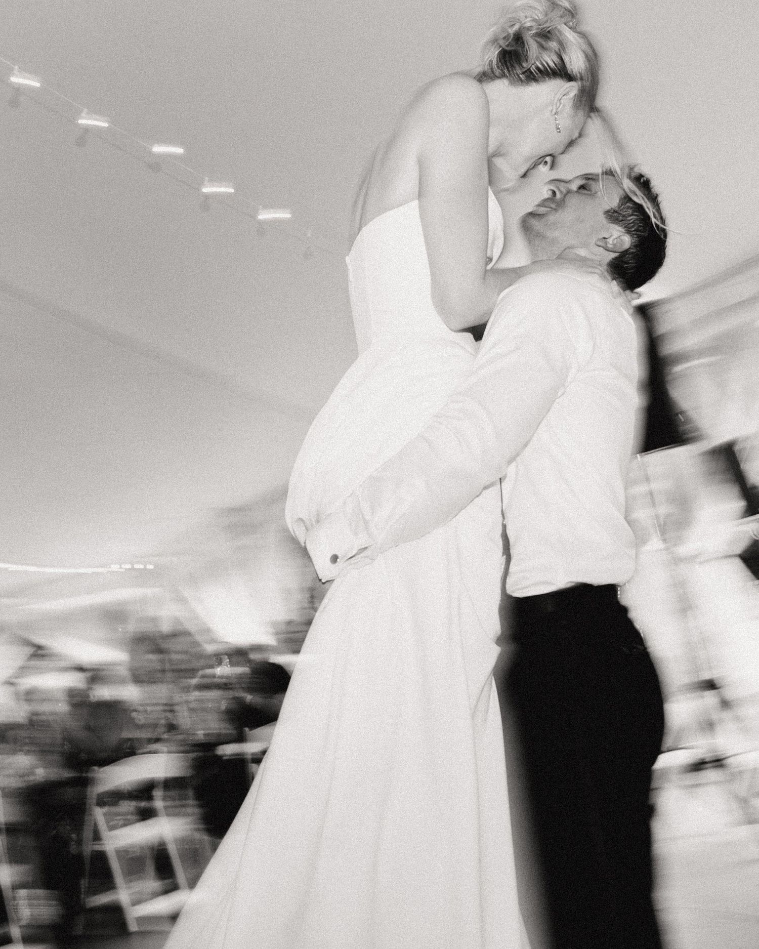 Black and white motion blur photos of a couple dancing at their wedding reception, showing movement and romance.