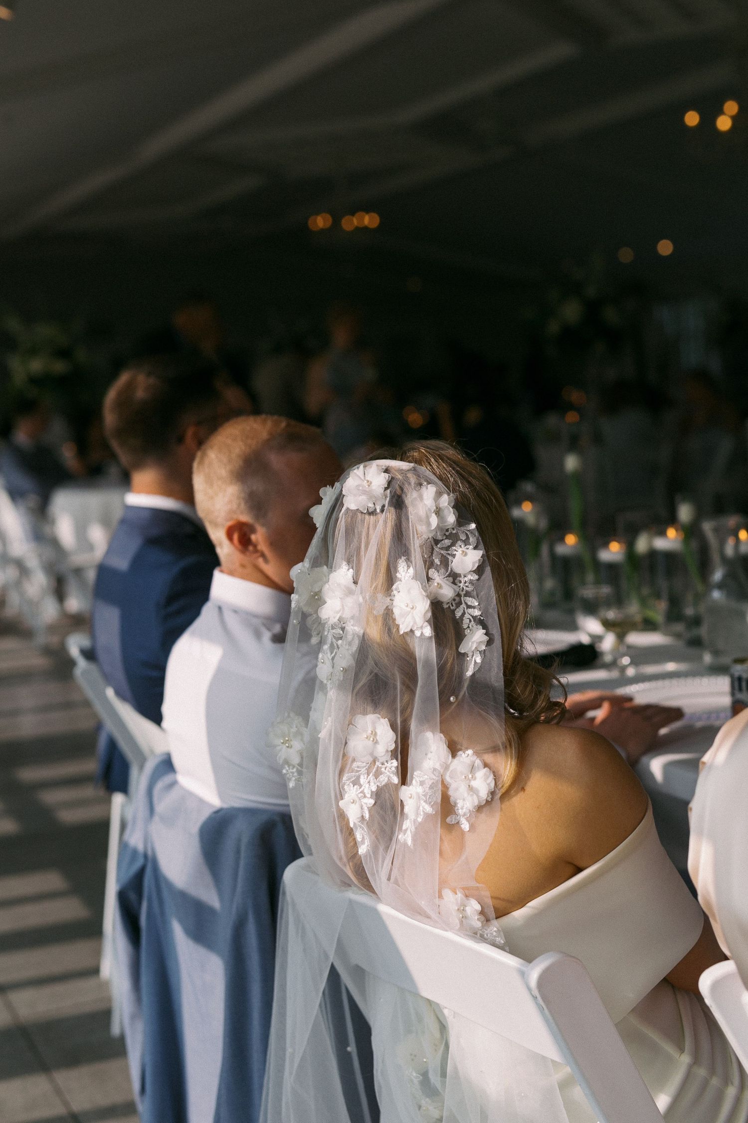 A couple shares an intimate first dance moment at their wedding reception under glittering lights.