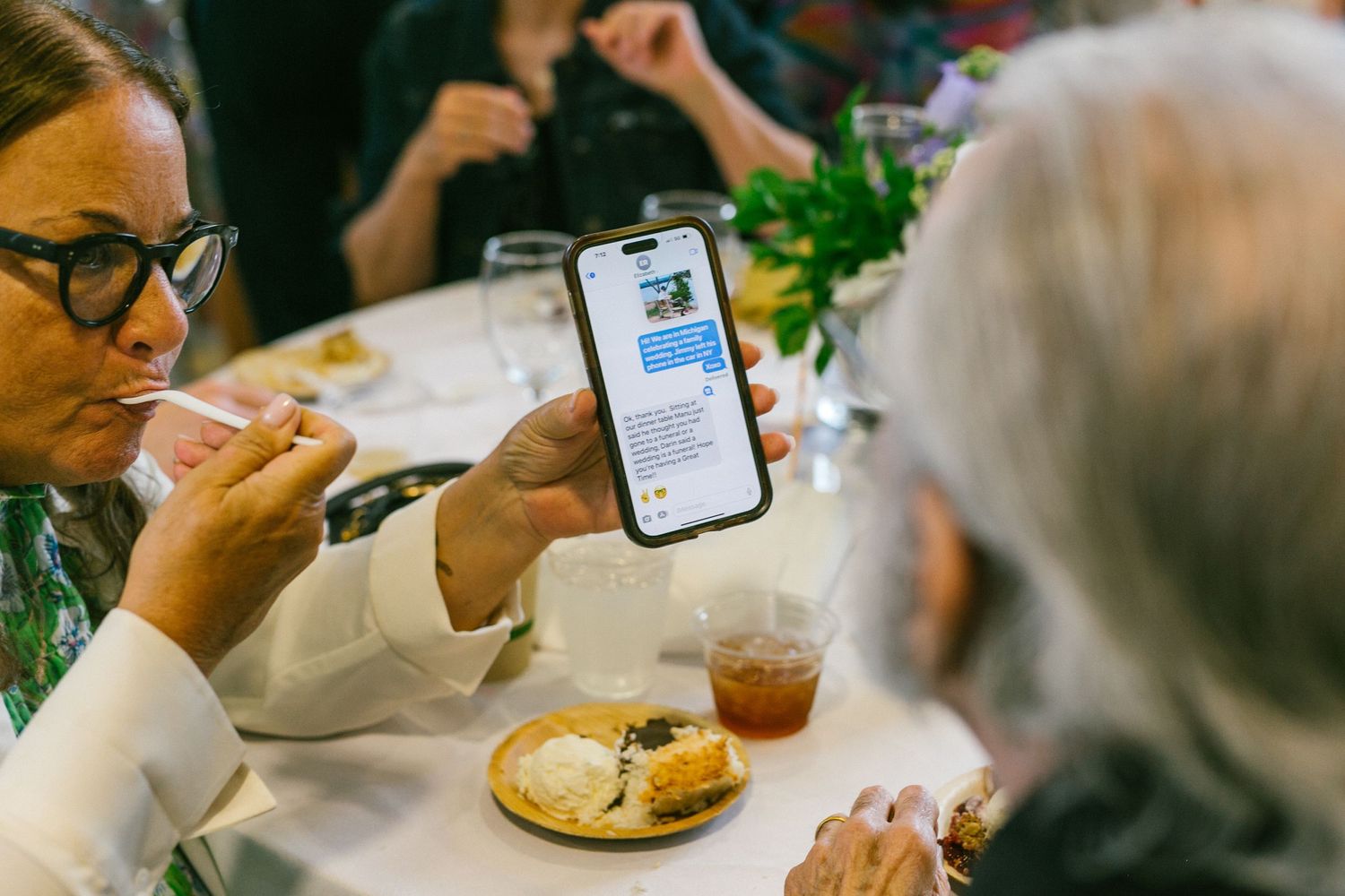 Two people sharing a meal while looking at a mobile phone display.