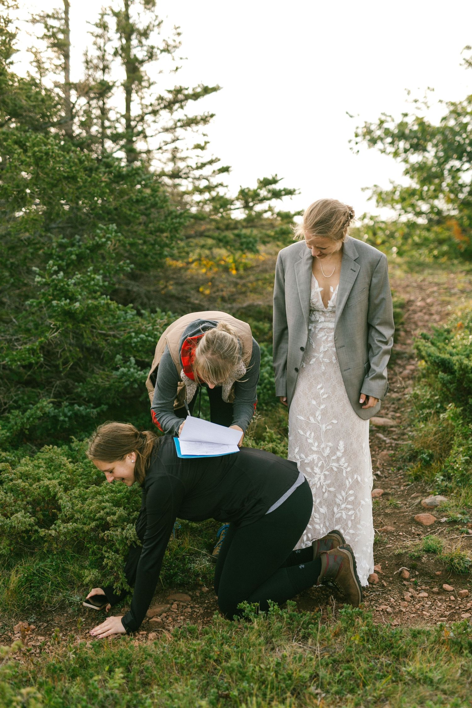 People in a natural outdoor setting with trees and greenery during a ceremony or special occasion.