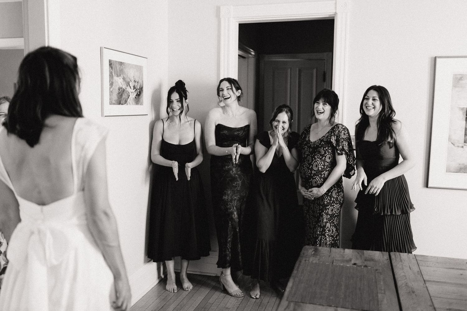 A series of black and white photographs displayed in a gallery showing people in formal attire.