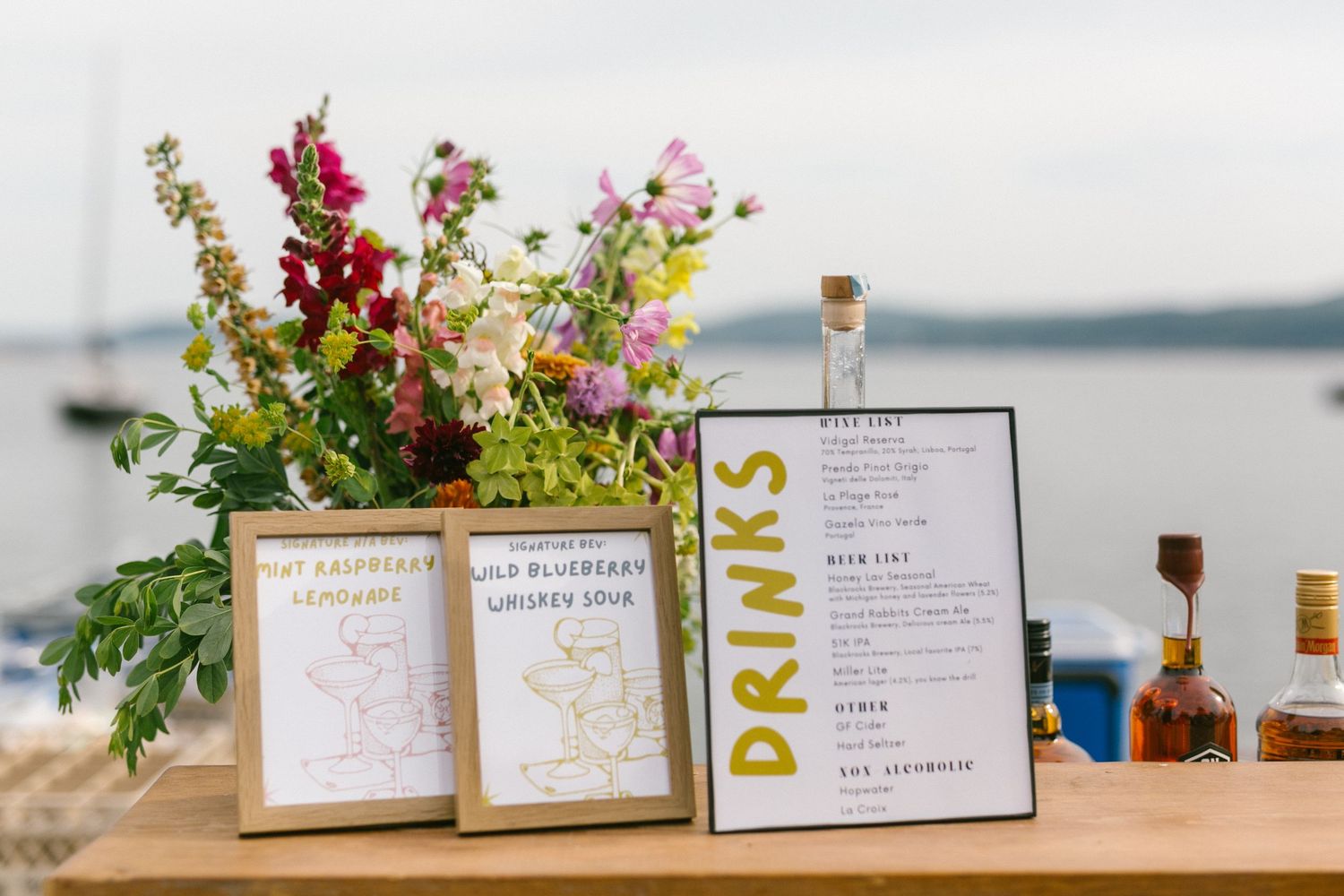 Wedding reception details showing elegant name cards and floral arrangements on a rustic wooden table.