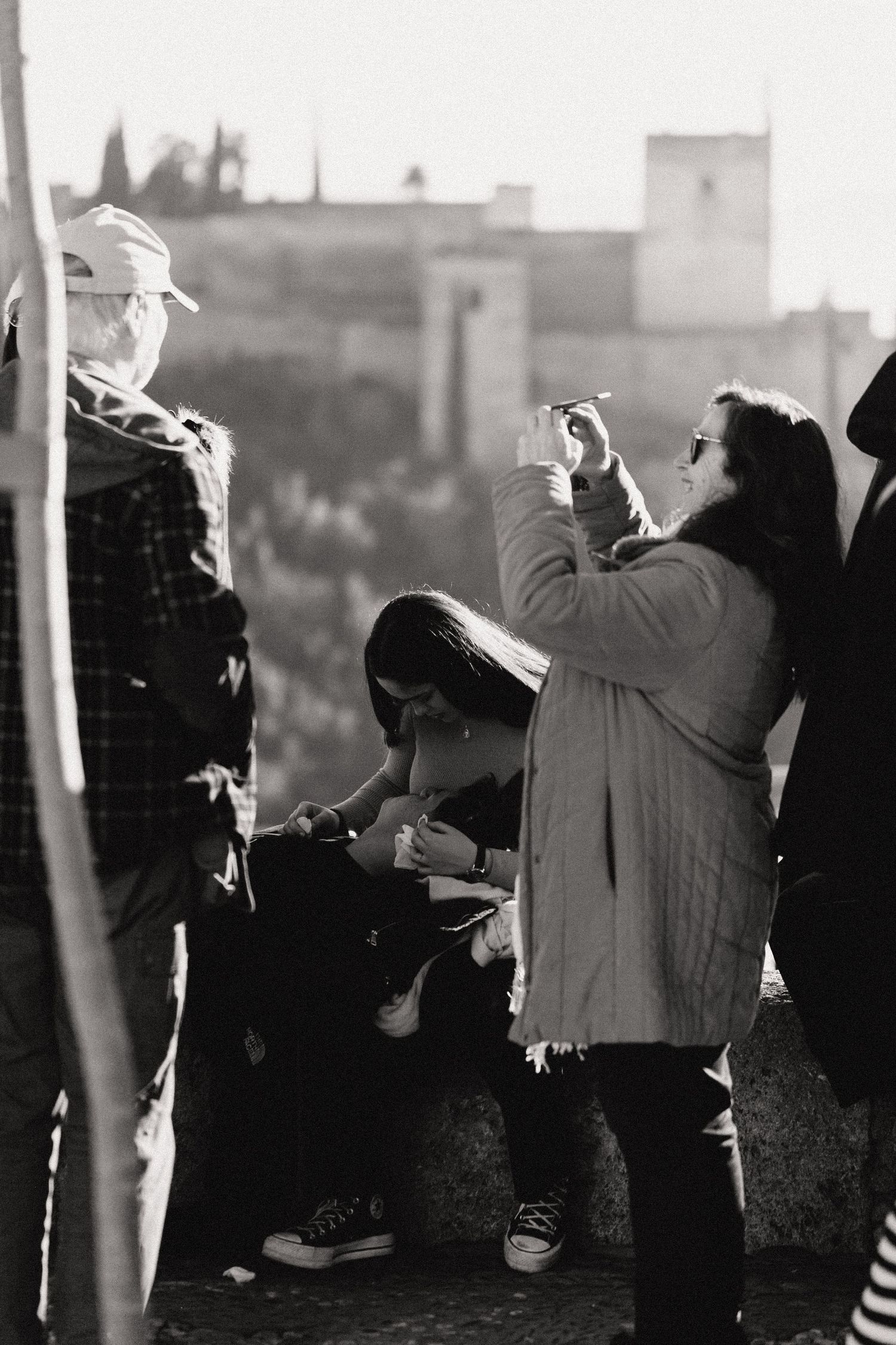 Tourist taking photos while sightseeing in a historic town on a sunny winter day.