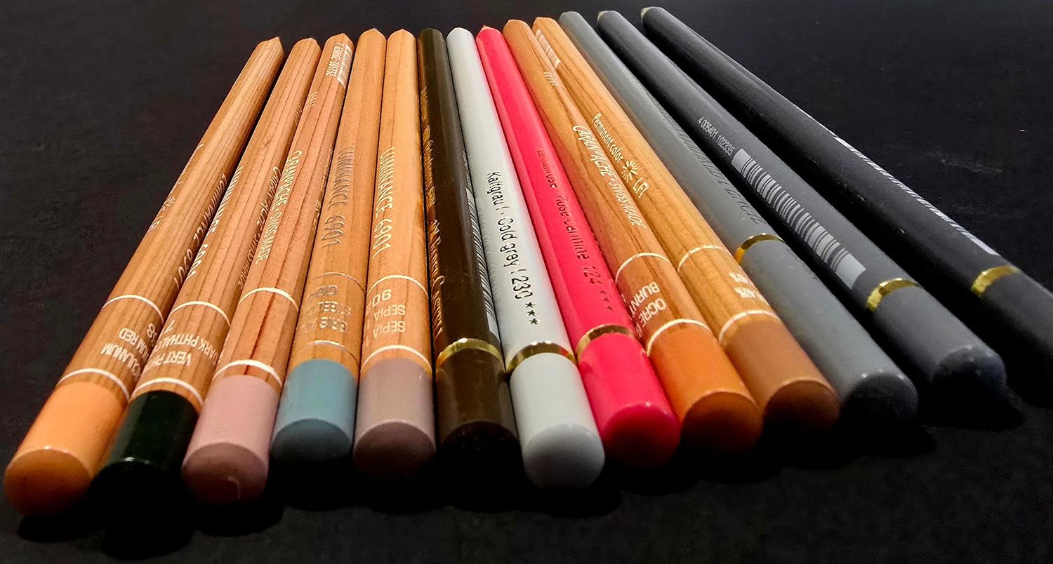 A collection of coloured pencils arranged in a row on a dark background. Adelaide, South Australia and regional South Australia