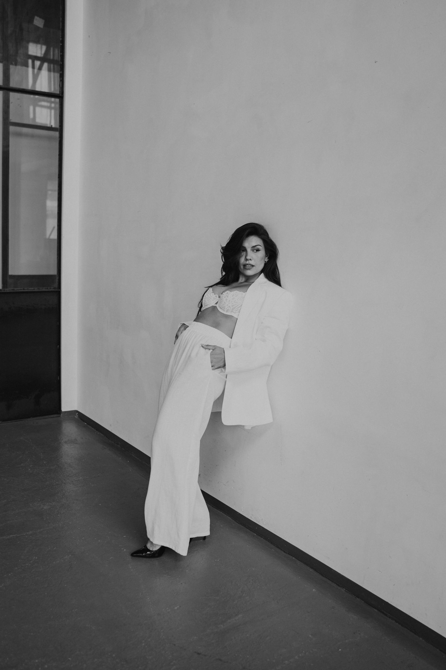 A sequence of black and white photos showing a figure in white clothing leaning at increasingly dramatic angles against a wall.
