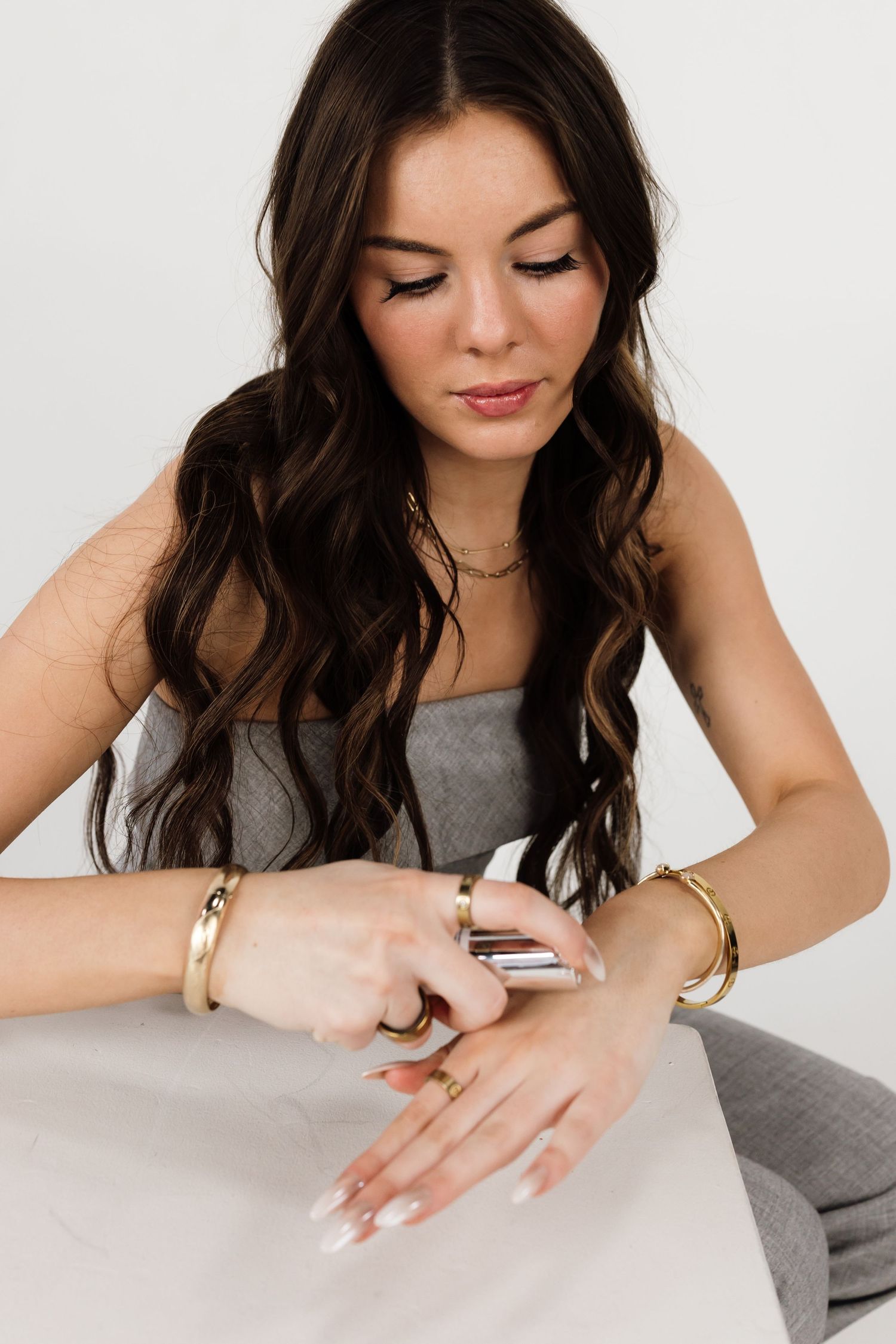 Close-up shots of hands and torso during beauty product demonstration.