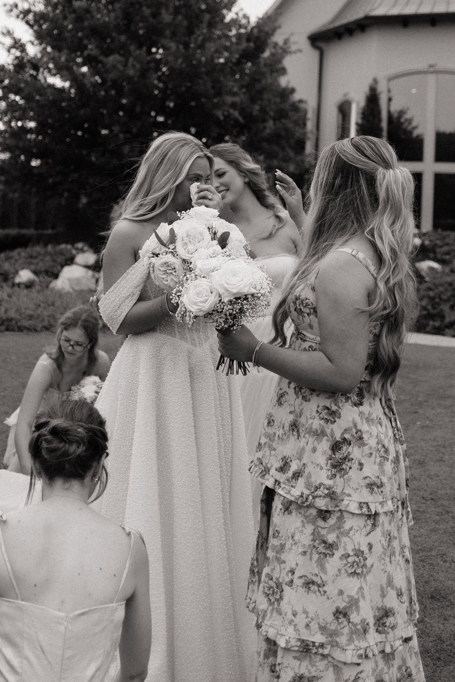 Group of people in floral dresses drinking and celebrating at an outdoor event.