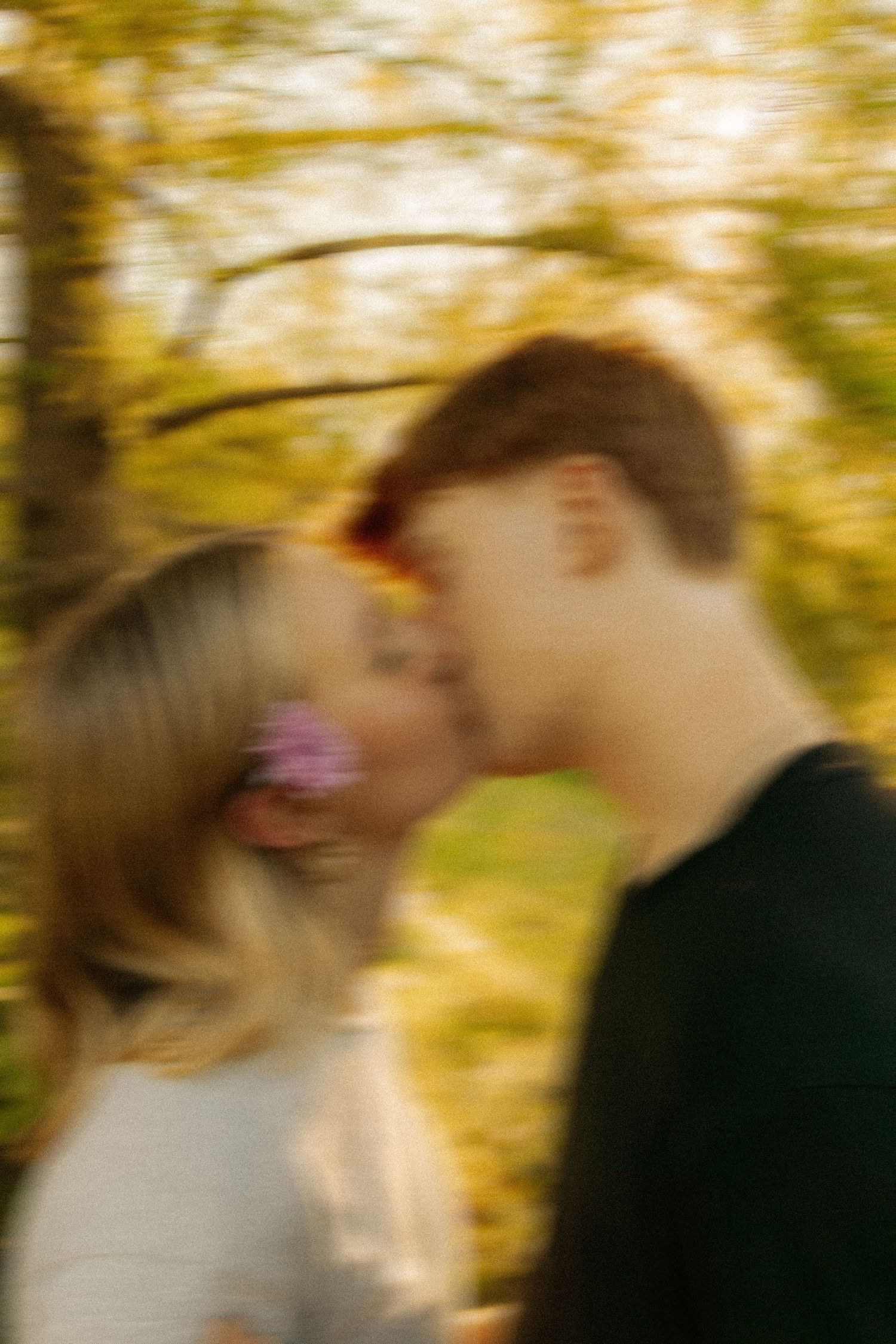 A blurred romantic scene captured in warm autumn lighting.