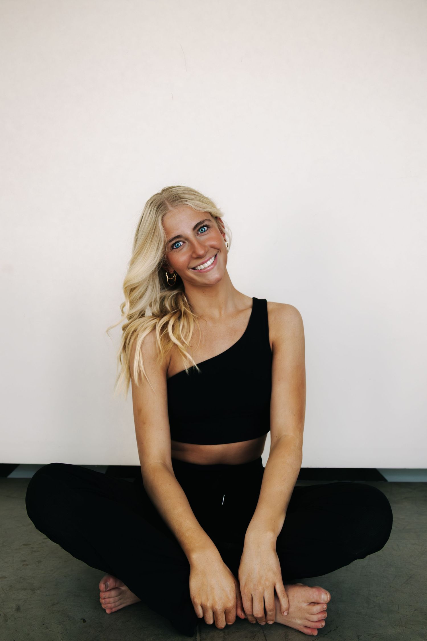 Casual studio session with black athletic wear showing playful seated poses.