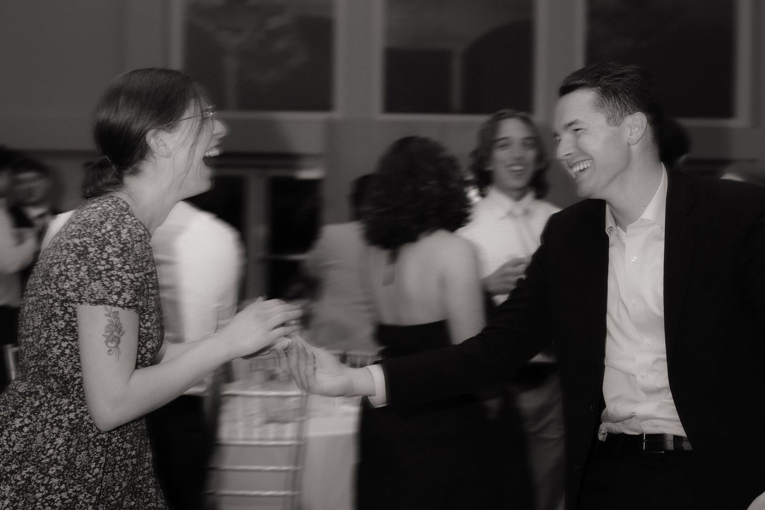 Couples dancing together at an indoor evening celebration.