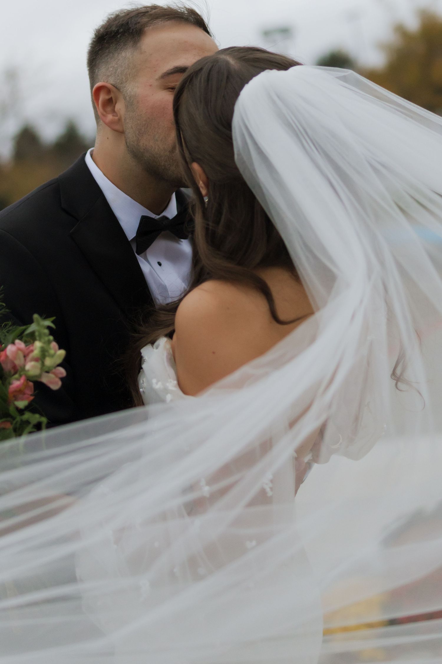 Flowing white wedding veil catches the breeze during an outdoor photo session.