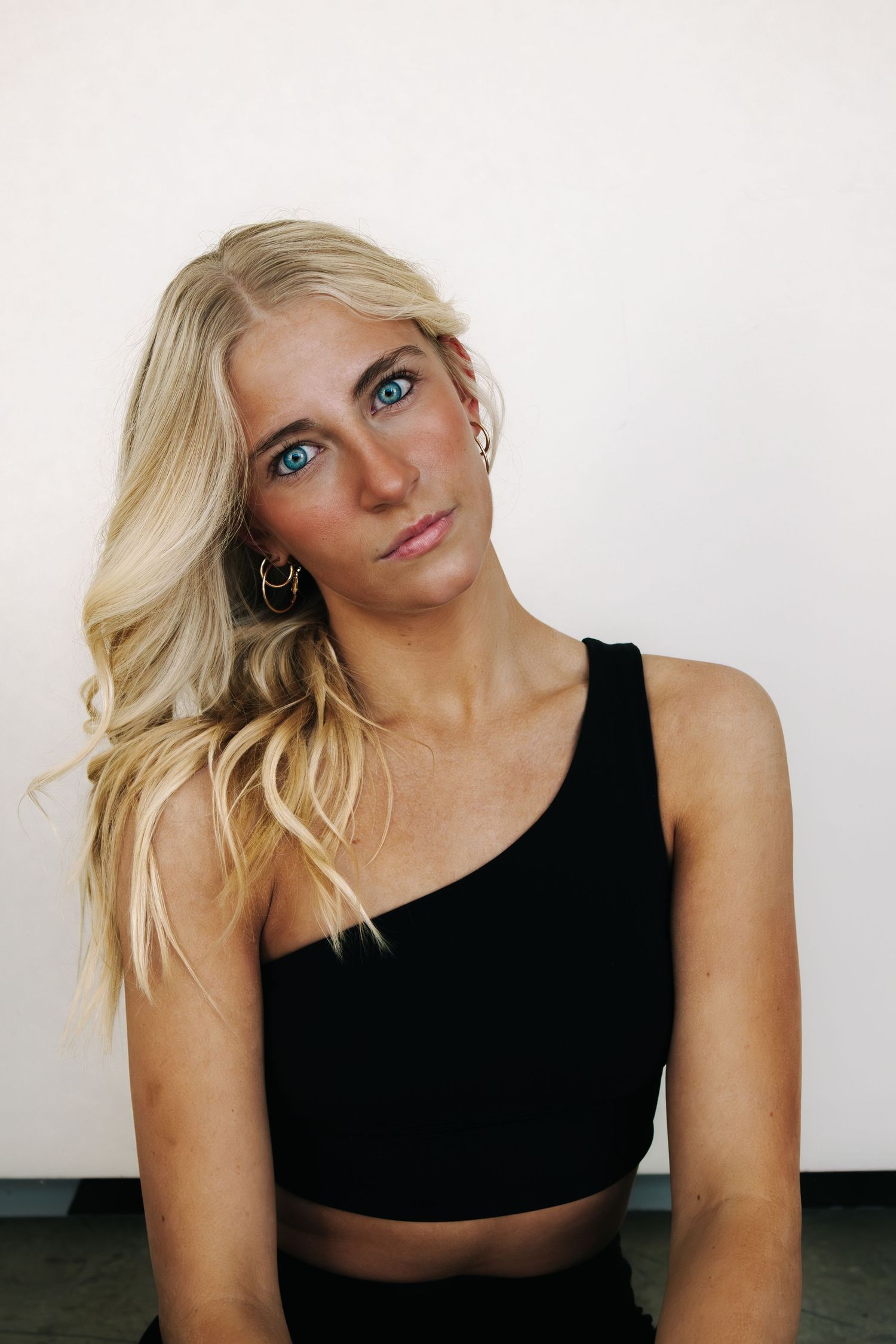 Studio portrait against white background wearing black athletic wear with dynamic poses.