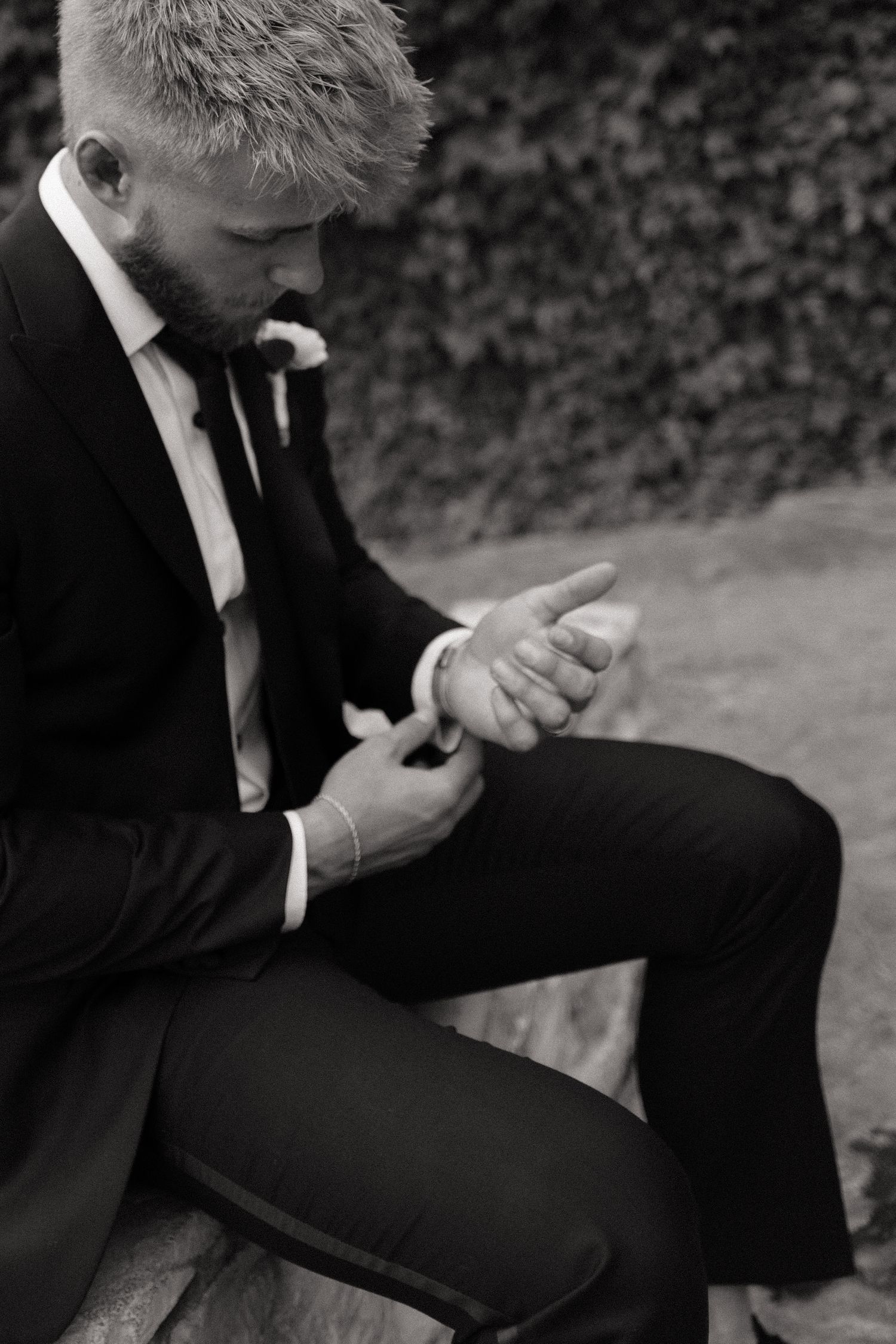 Black and white sequence of someone in formal attire adjusting their clothing.