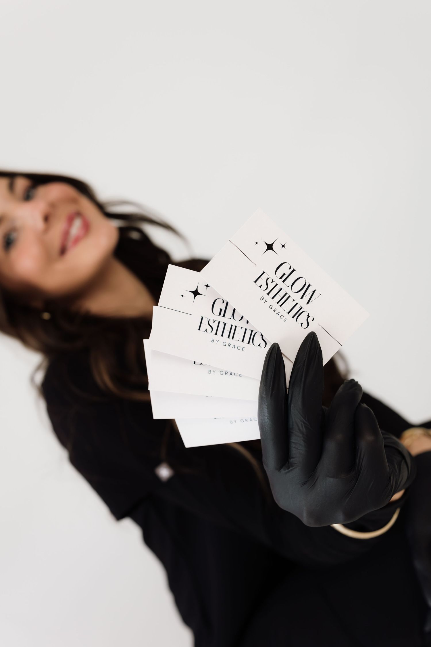 Stylish black gloves holding business cards during fashion photoshoot.