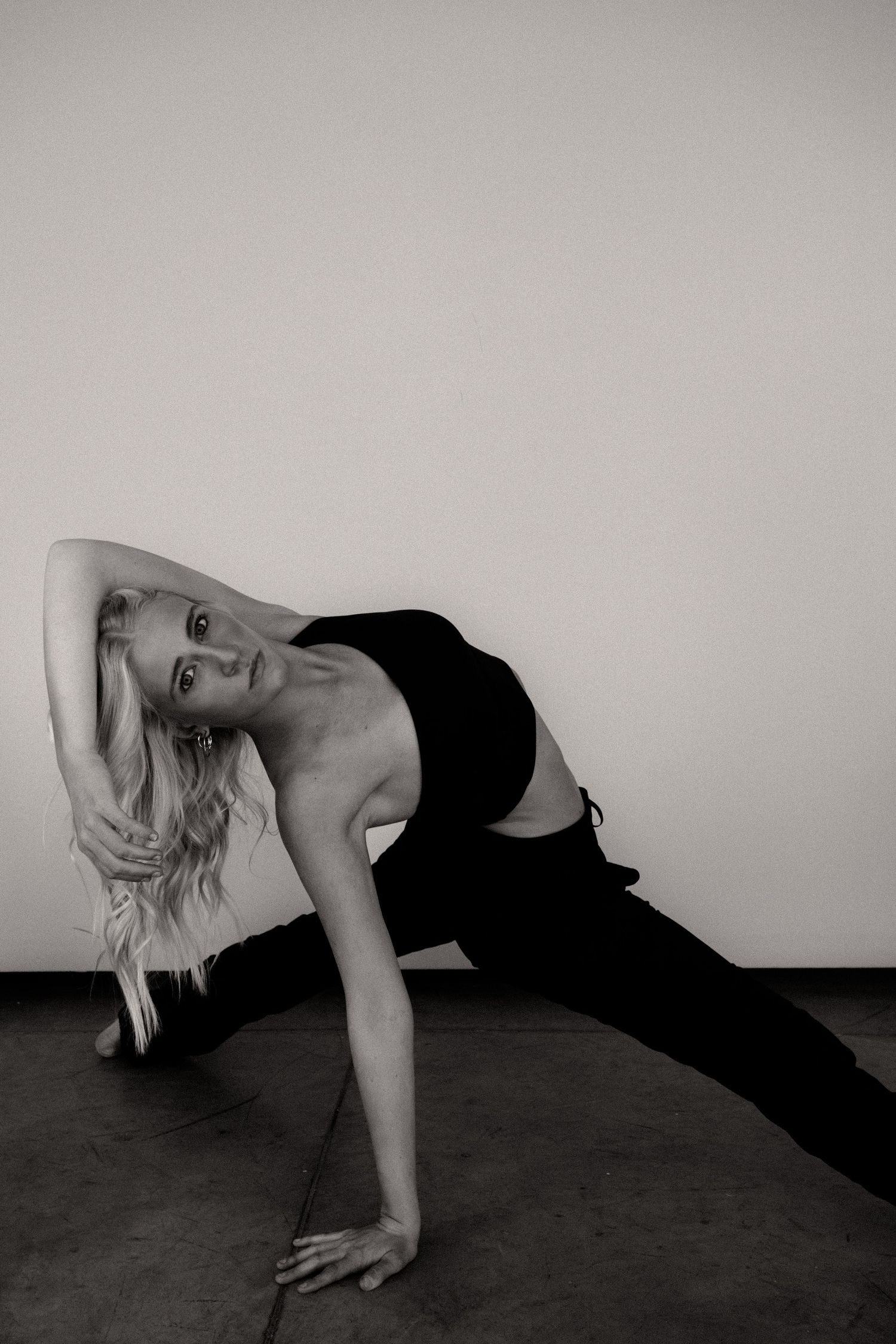 Black and white series of a person in dark clothing performing floor exercises against a light background.