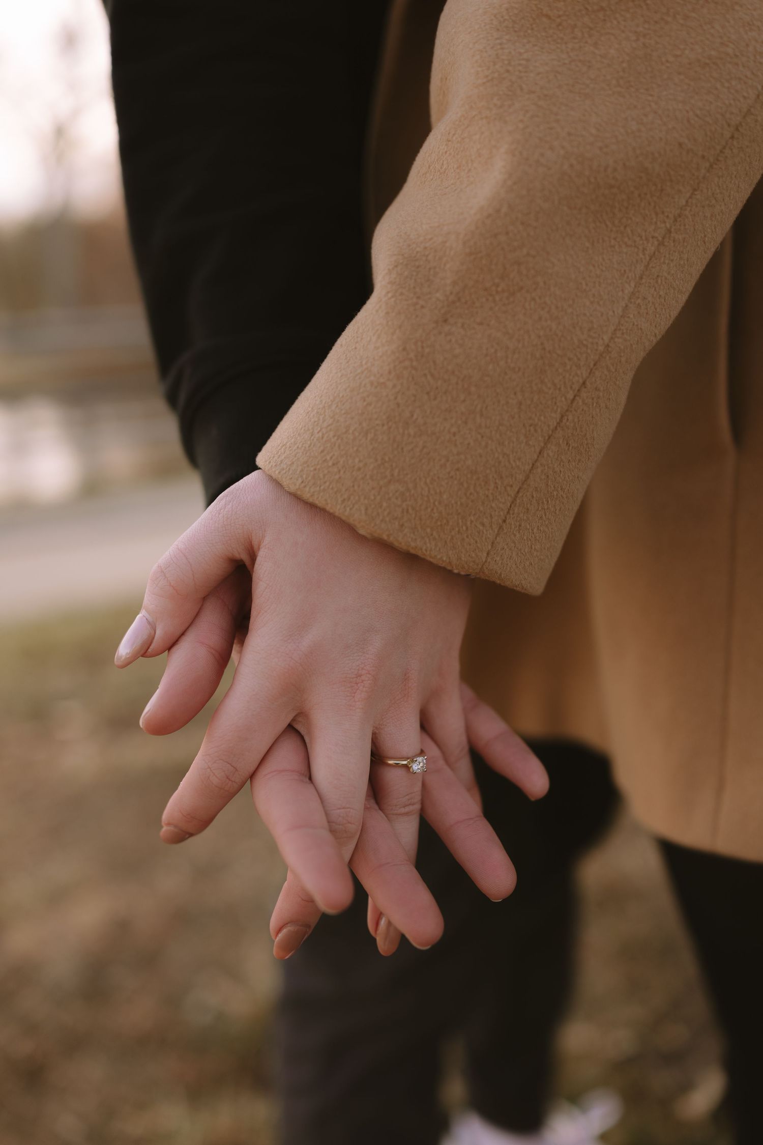 A close-up of hands showing off a new engagement ring.
