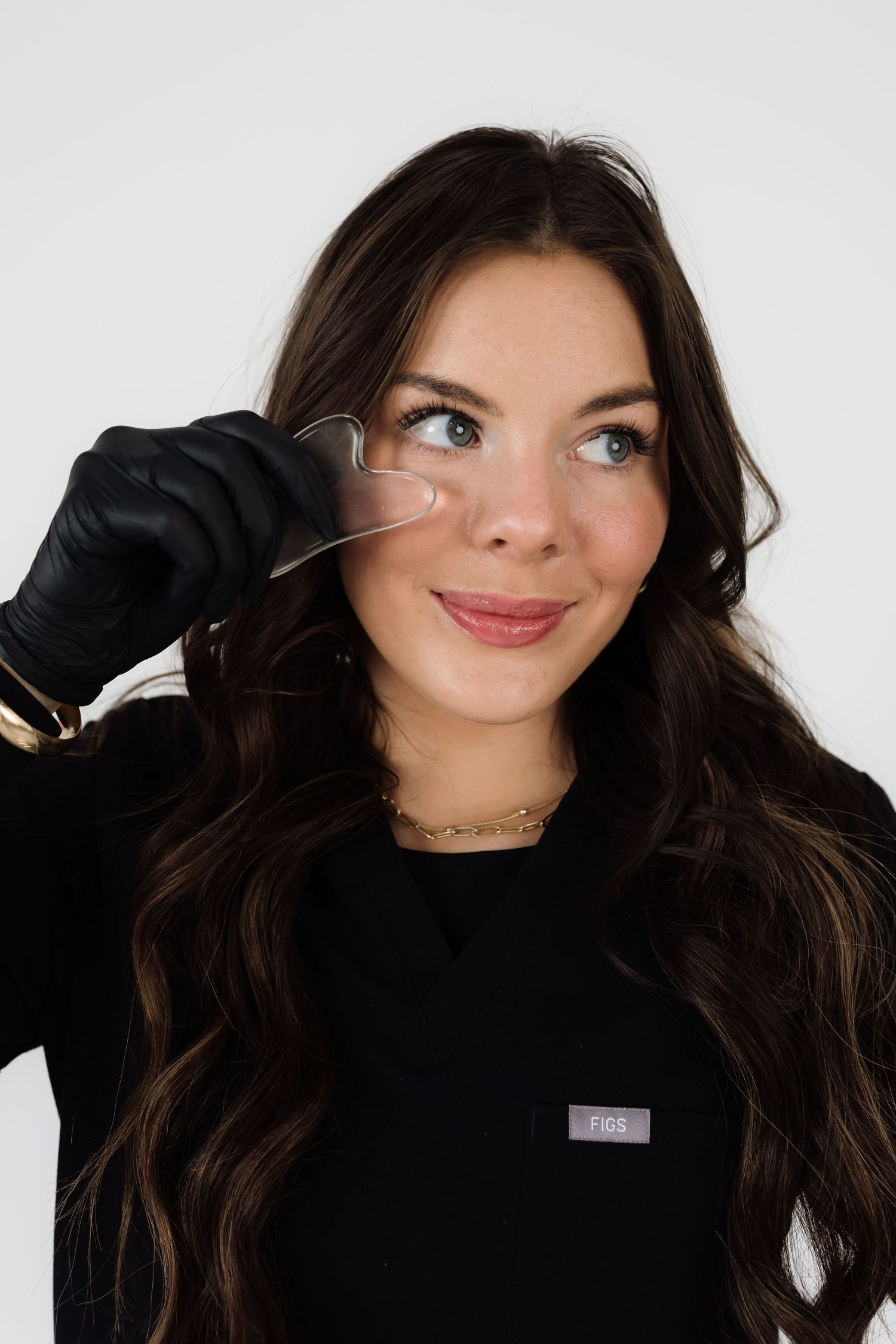 Studio fashion shoot showcasing black sweater and natural wavy hair.