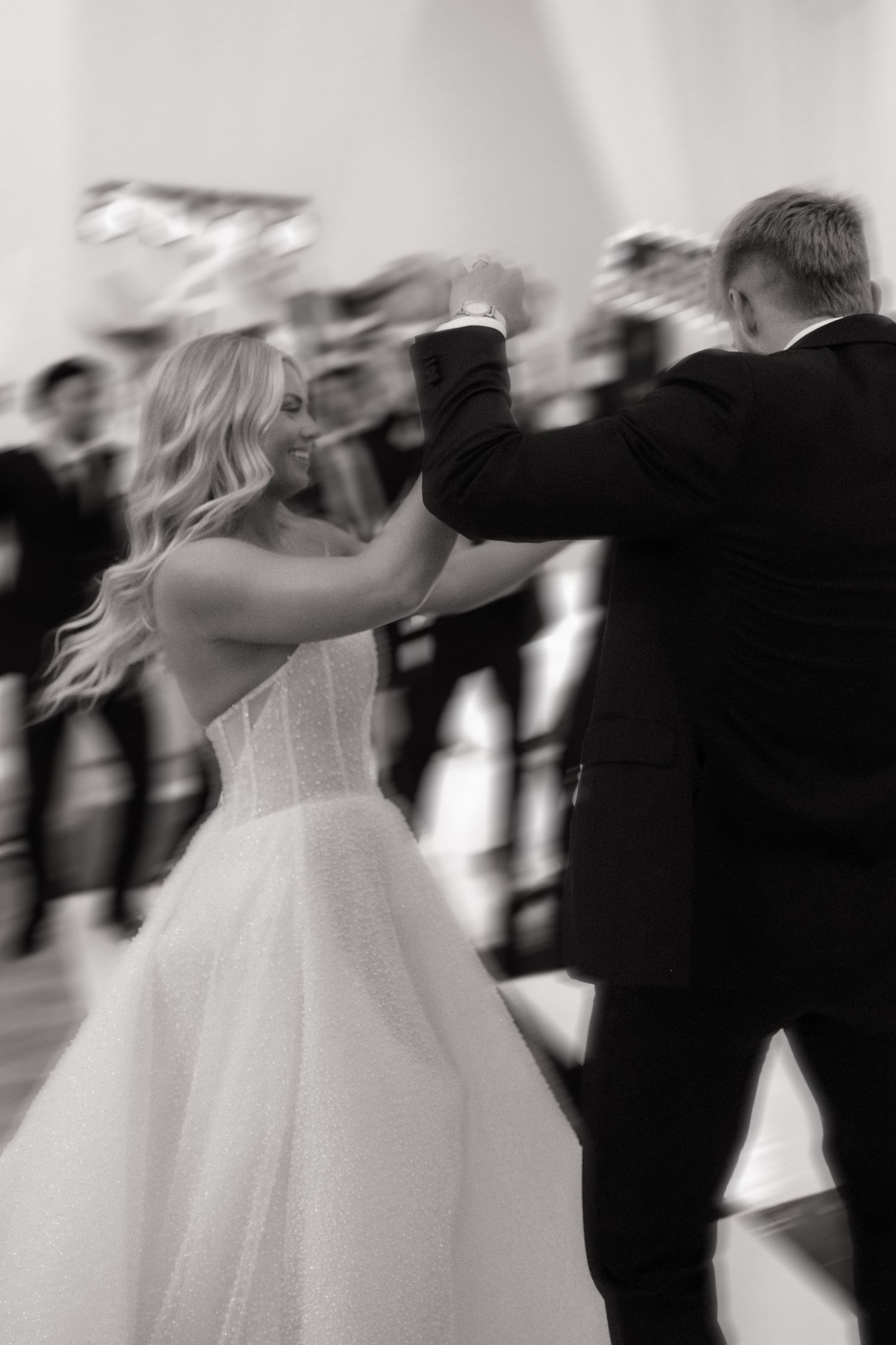 Motion blur of wedding couple dancing at reception in black and white.