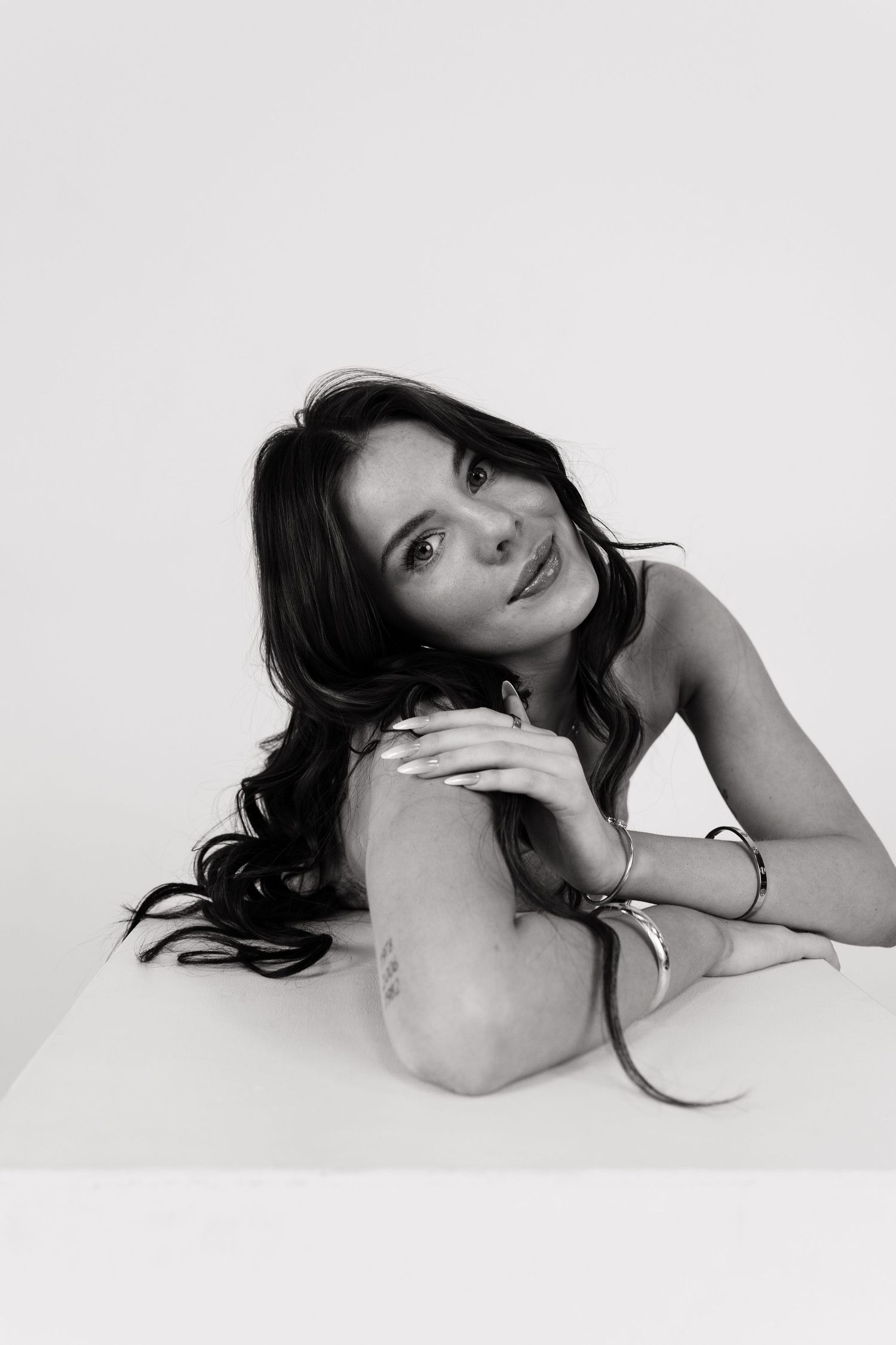 Artistic black and white portrait series showing graceful poses against a white background.