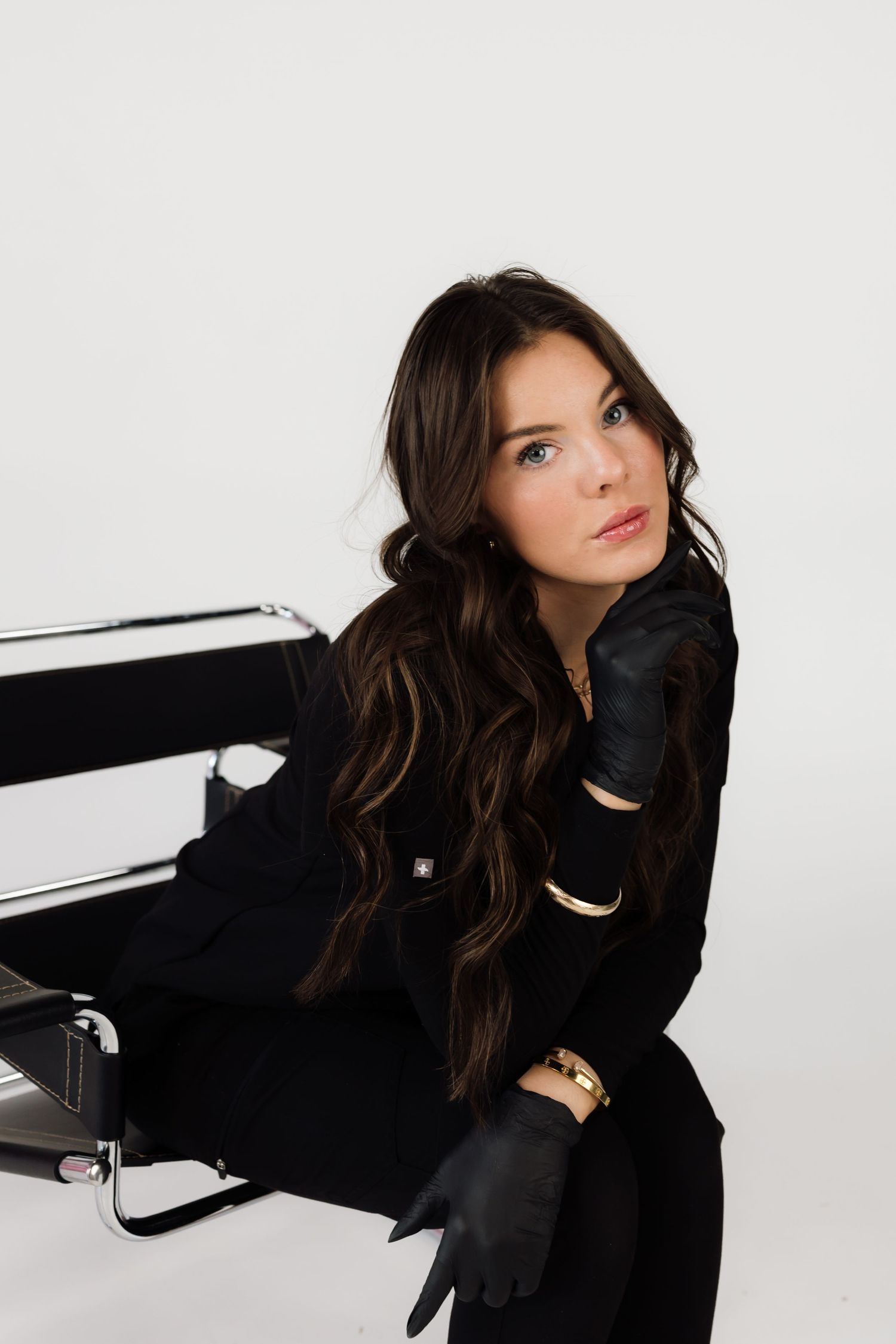 Stylish portrait session featuring all-black outfit against clean white studio backdrop.