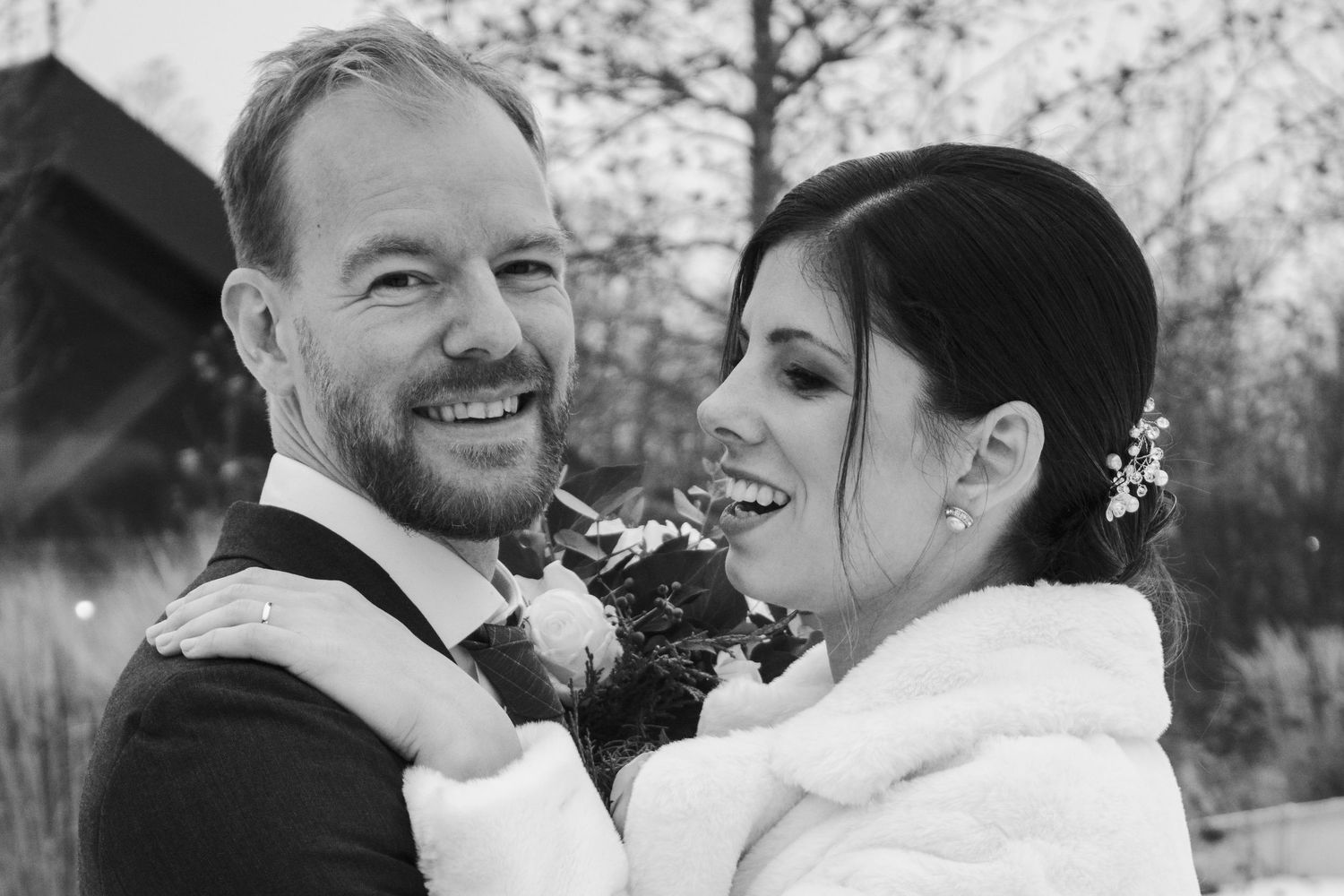 Wedding couple shares candid laughter and joy during their winter celebration.