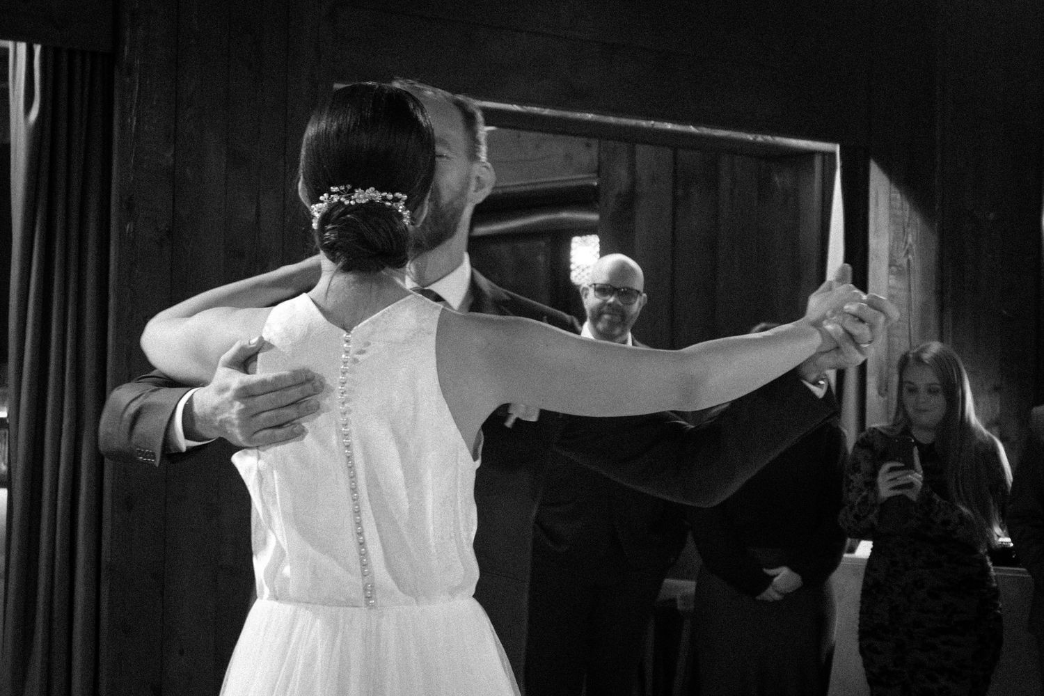 A silhouetted wedding couple dancing in a darkened venue.