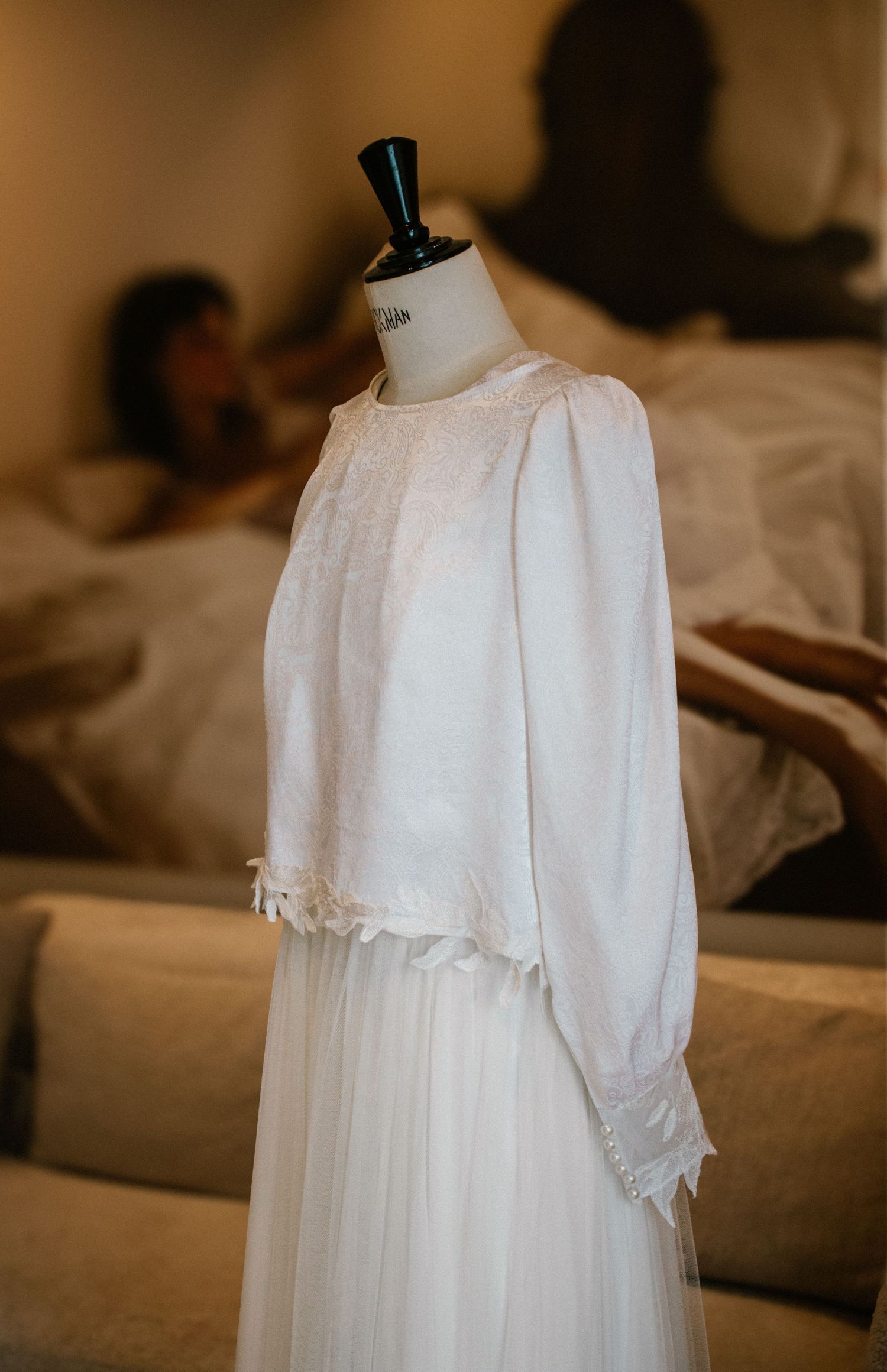 Vintage-style white christening or baptism gown displayed on a mannequin.