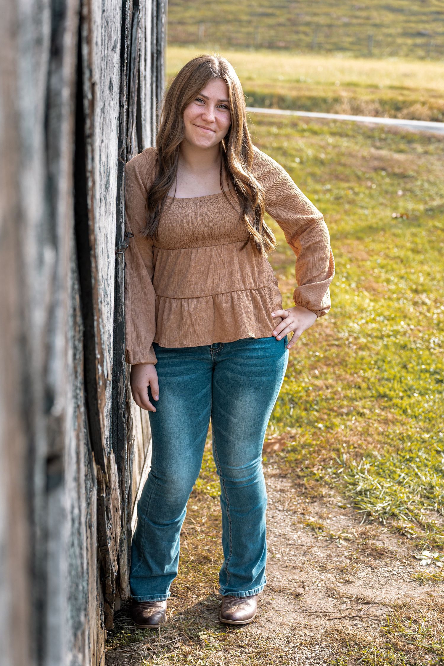 A series of outdoor portraits showing someone wearing a brown top and blue jeans posing against a rustic wooden fence.