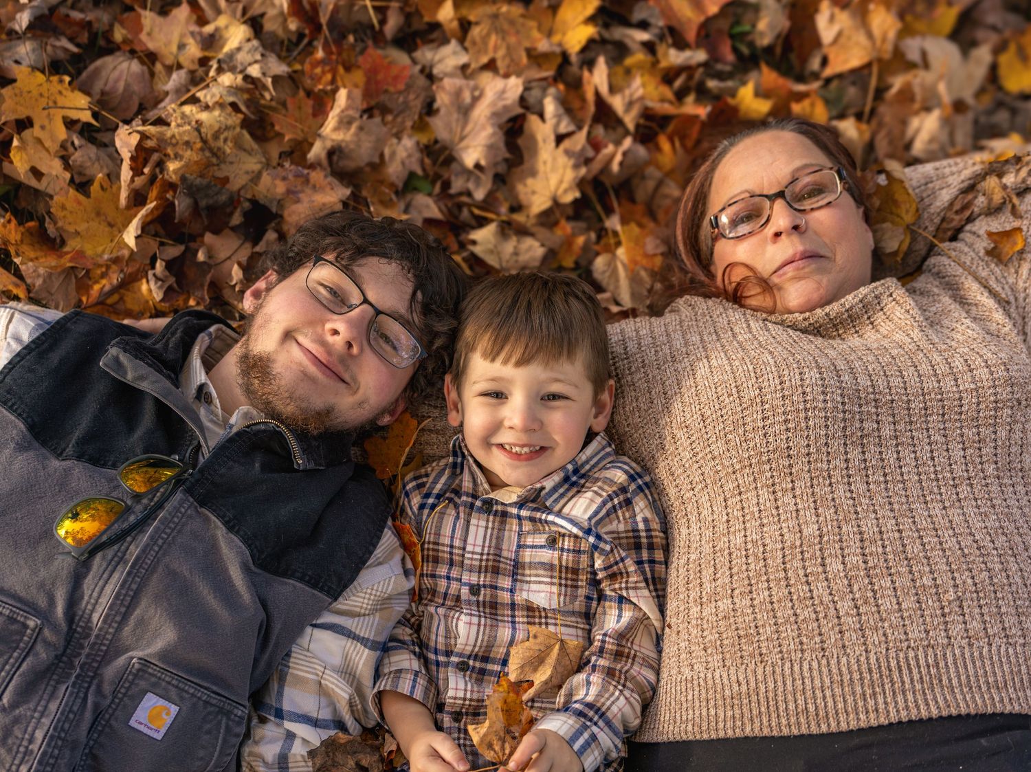 A series of autumn photos showing people lying in fallen leaves while wearing casual sweaters and plaid clothing.