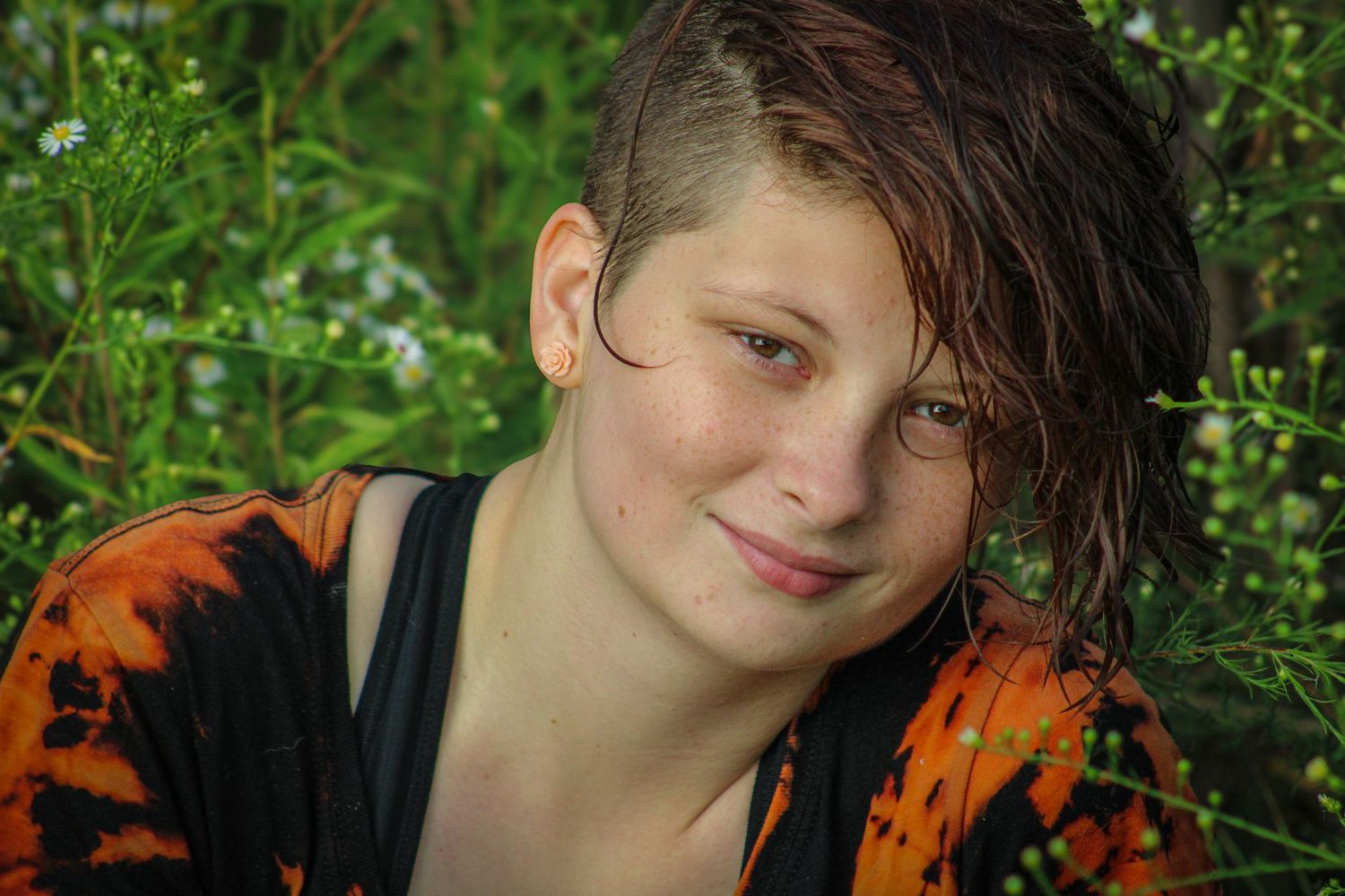 A series of similar photos showing someone in an orange and black shirt against a green leafy background.