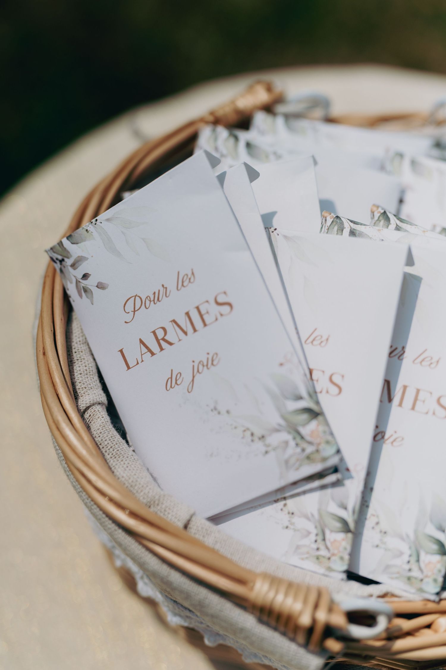 Basket of French wedding tissue packets reading Pour les Larmes de Joie for happy tears.