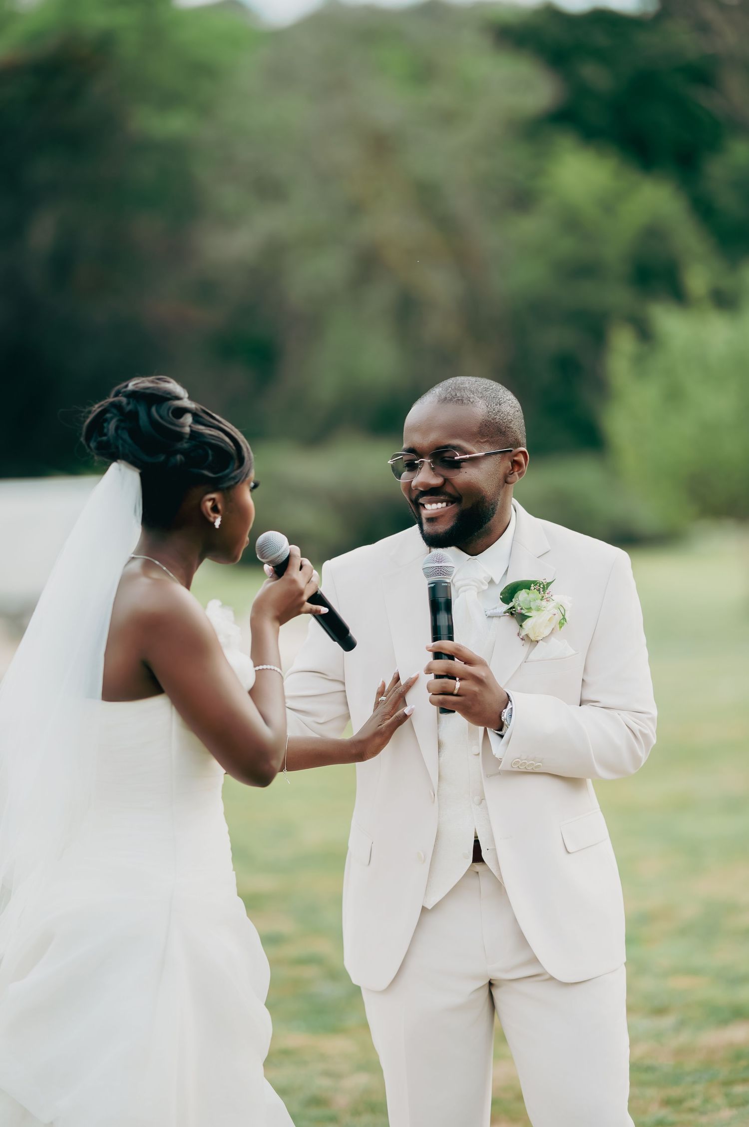 Bride and groom exchange heartfelt vows with microphones during outdoor wedding ceremony.